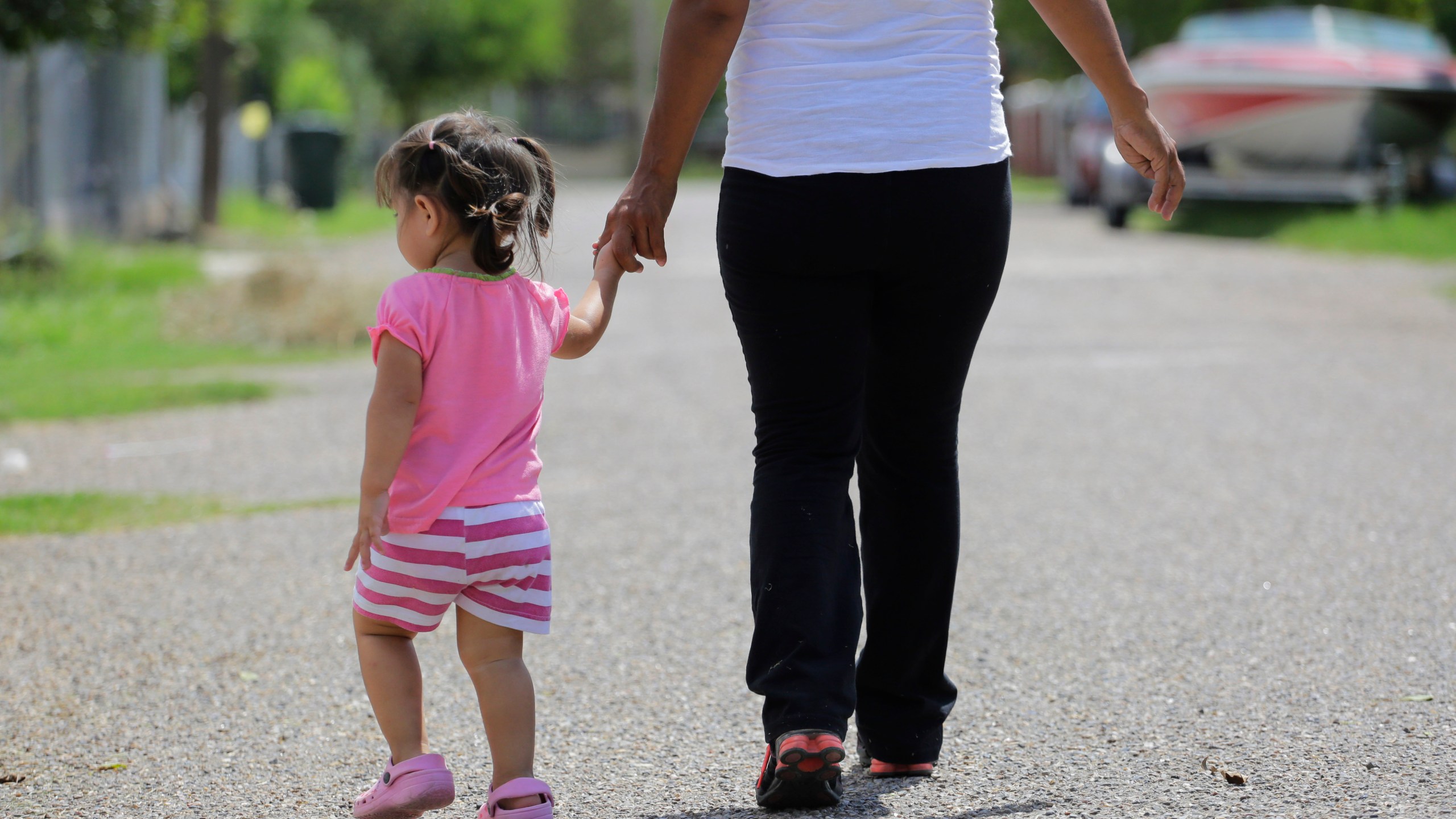 FILE - In this Sept. 16, 2015, photo, a woman in Sullivan City, Texas, who said she entered the country illegally, walks with her daughter who was born in the United States, but was denied a birth certificate. (AP Photo/Eric Gay, File)