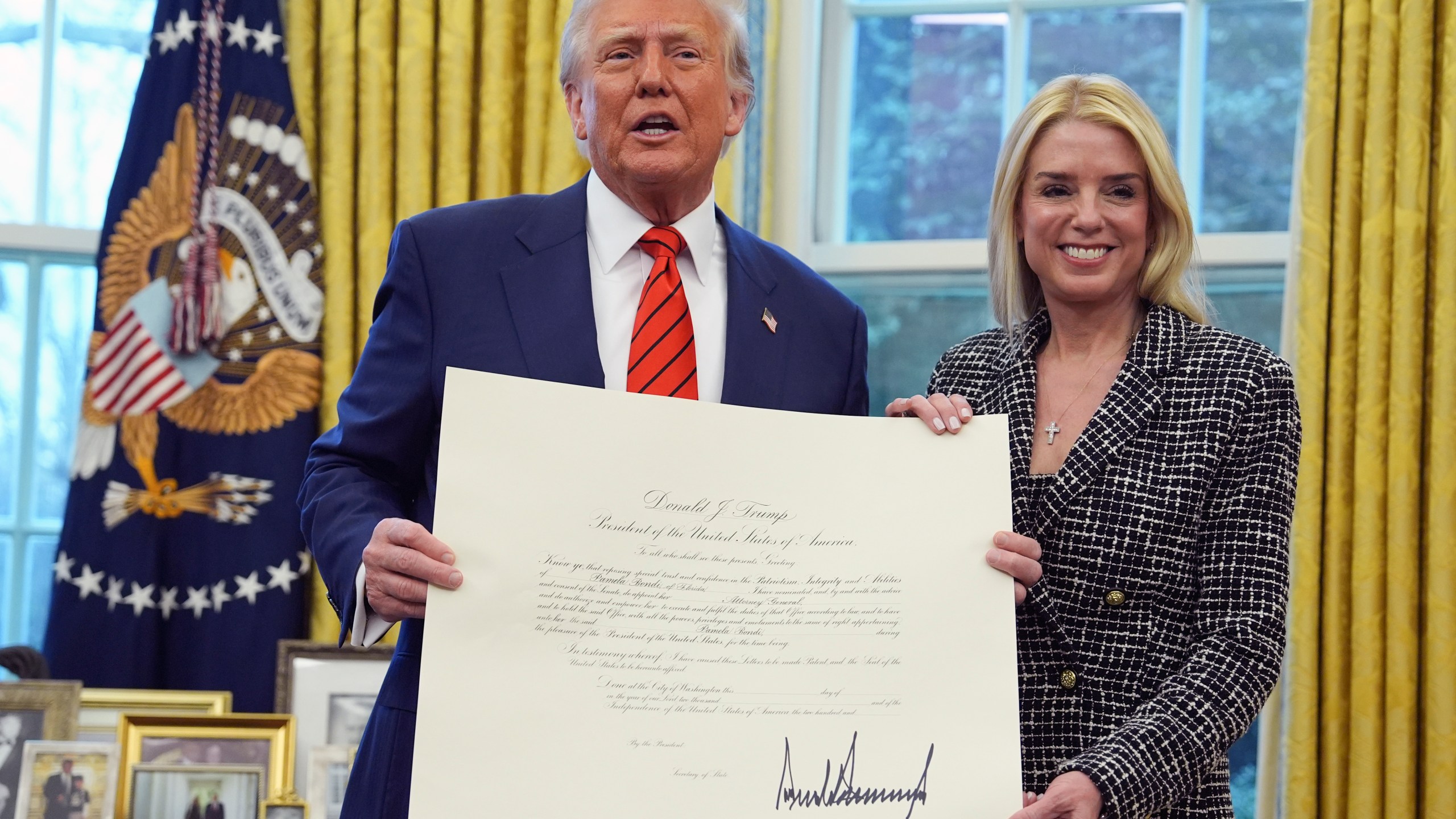 President Donald Trump presents Attorney General Pam Bondi with a document, after she was sworn in by Supreme Court Associate Justice Clarence Thomas, in the Oval Office of the White House, Wednesday, Feb. 5, 2025, in Washington. (AP Photo/Evan Vucci)