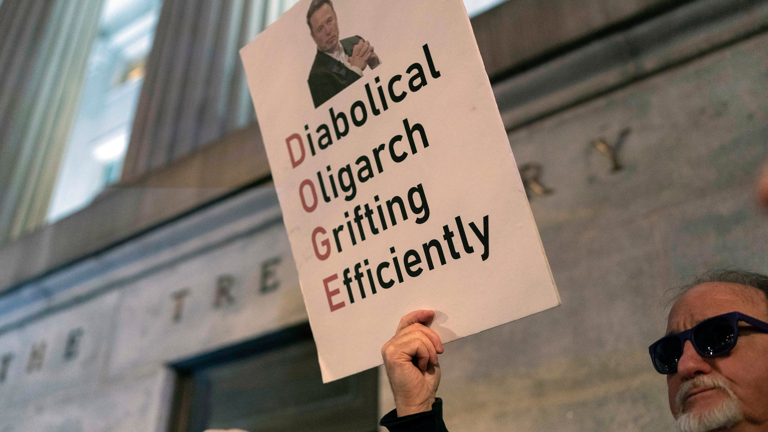 People protest during a rally against Elon Musk outside the Treasury Department in Washington, Tuesday, Feb. 4, 2025. (AP Photo/Jose Luis Magana)