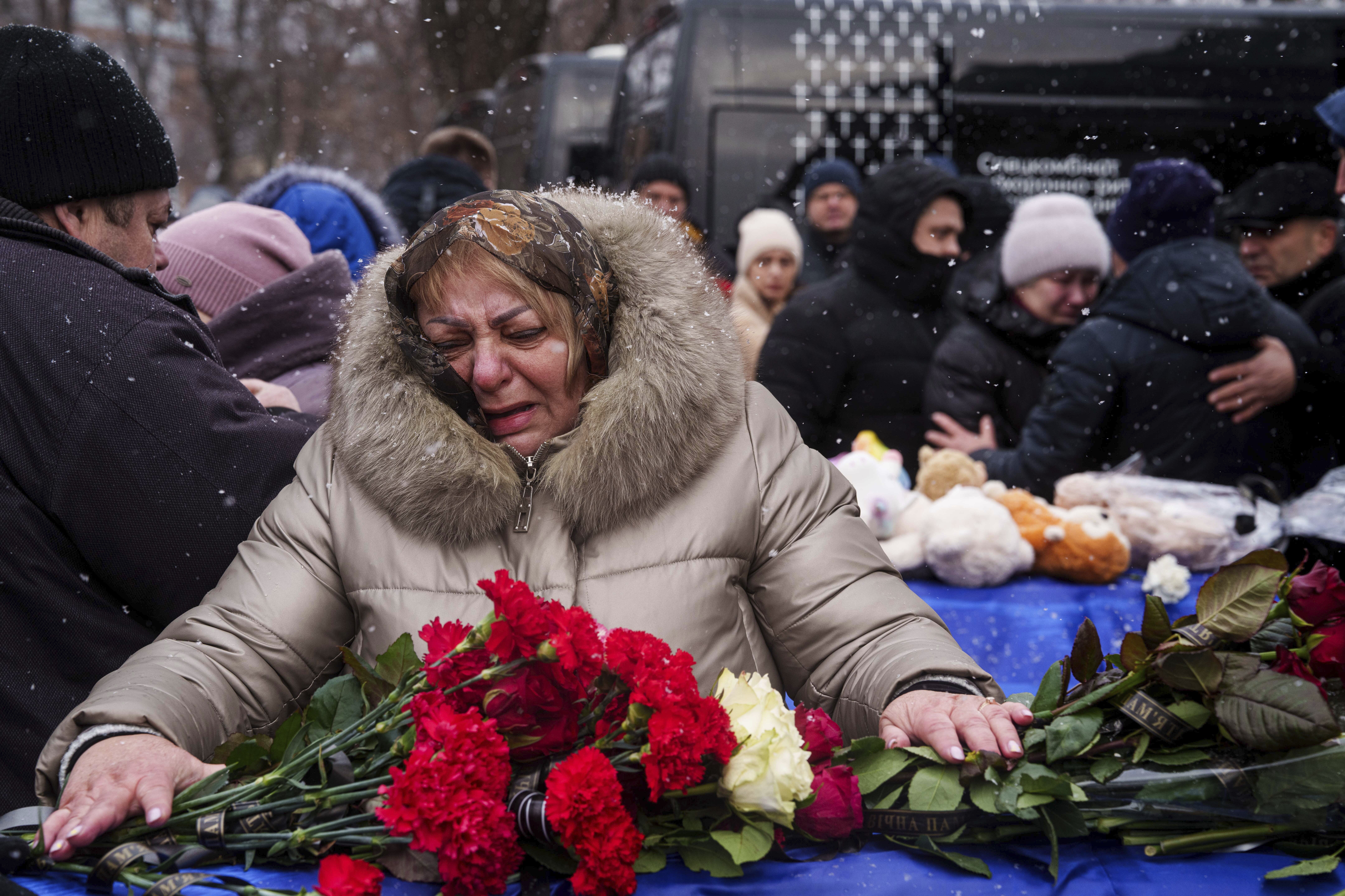 Relatives say goodbye to Dmytro Yavorskyi, 37, Sofia Yavorska, 9, Olena Yavorska 38, who were killed on Feb. 1 by a Russian strike on residential building during a funeral ceremony in Poltava, Ukraine, Wednesday, Feb. 5, 2025. (AP Photo/Evgeniy Maloletka)