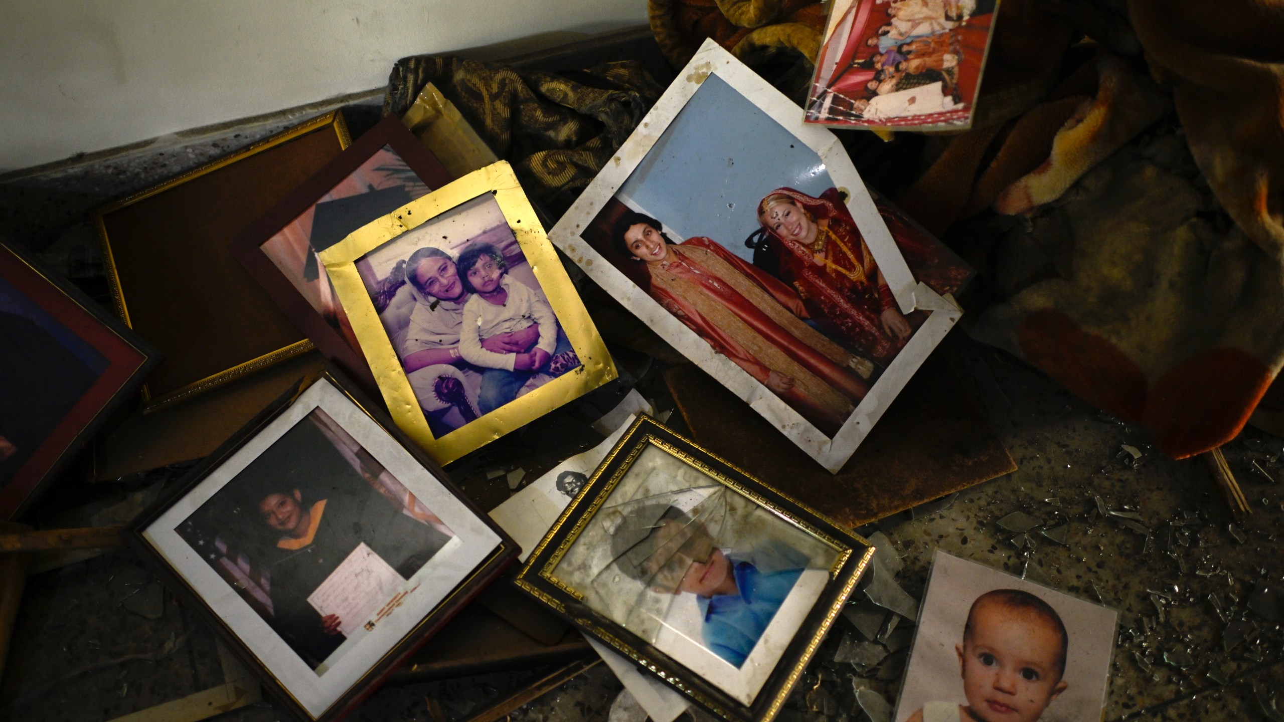 Family photographs on the floor in a room of the vandalized residence of Bangladesh's ousted Prime Minister Sheikh Hasina, in Dhaka, Bangladesh, Thursday, Feb. 6, 2025. (AP Photo/Mahmud Hossain Opu)