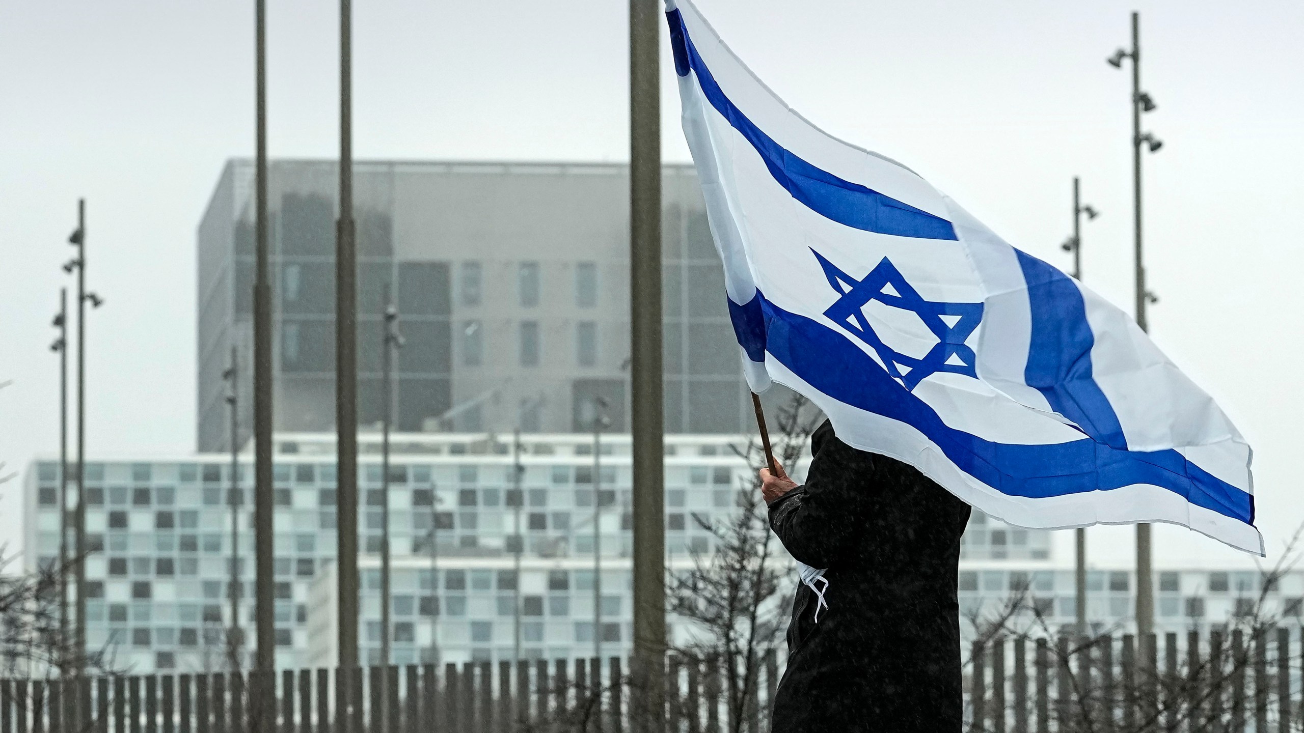 FILE - A woman holds an Israeli flag in front of International Criminal Court at The Hague, Netherlands, Feb. 14, 2024. (AP Photo/Martin Meissner, File)