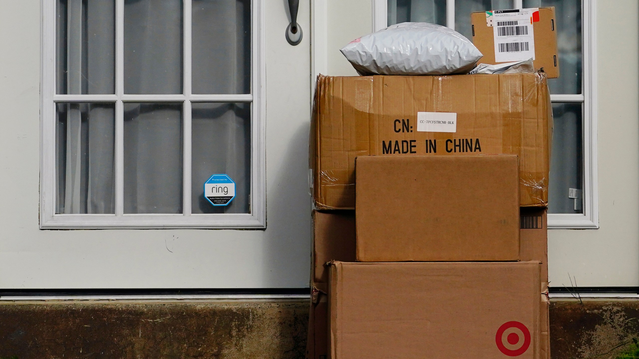 FILE - Packages are seen stacked on the doorstep of a residence, Wednesday, Oct. 27, 2021, in Upper Darby, Pa. (AP Photo/Matt Slocum, File)