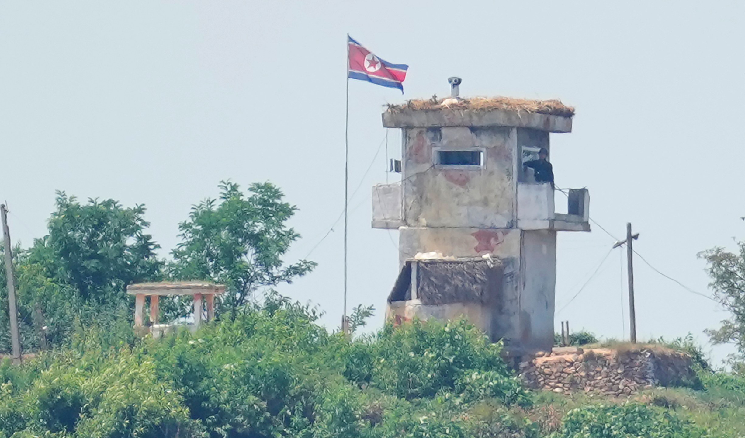 FILE - A soldier stands at a North Korean military guard post flying a national flag, seen from Paju, South Korea, June 26, 2024. (AP Photo/Lee Jin-man, File)