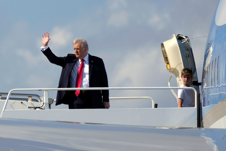 President Donald Trump, left, waves as he boards Air Force One with grandson Theodore, Ivanka Trump's son, at Palm Beach International Airport in West Palm Beach, Fla., Sunday, Feb. 9, 2025. (AP Photo/Ben Curtis)