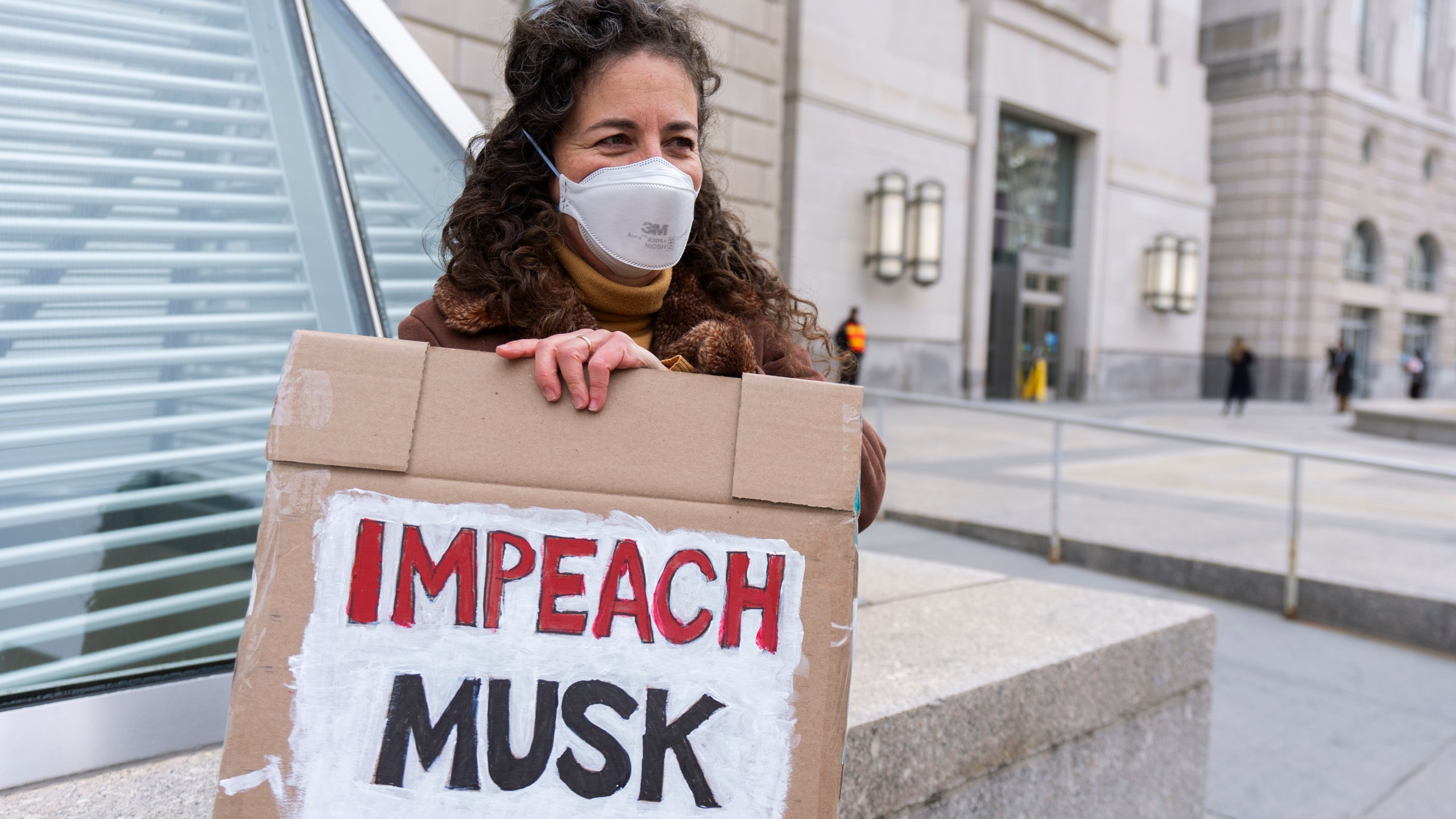 A United States Agency for International Development, or USAID contract worker, carries a sign outside the USAID headquarters in Washington, Monday, Feb. 10, 2025. (AP Photo/Manuel Balce Ceneta)