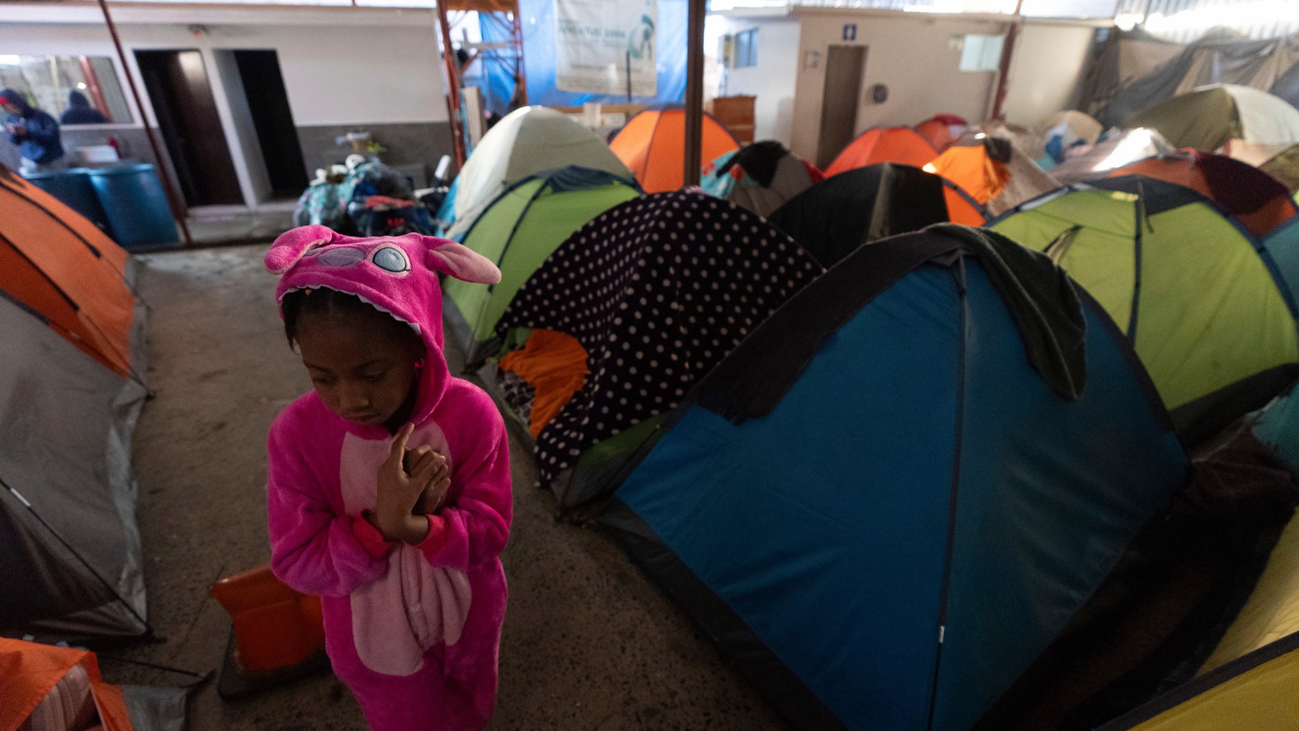 Maickeliys Rodriguez, 6, of Venezuela, leaves her tent at a migrant shelter on a chilly morning in Tijuana, Mexico, Saturday, Feb. 1, 2025. (AP Photo/Gregory Bull)