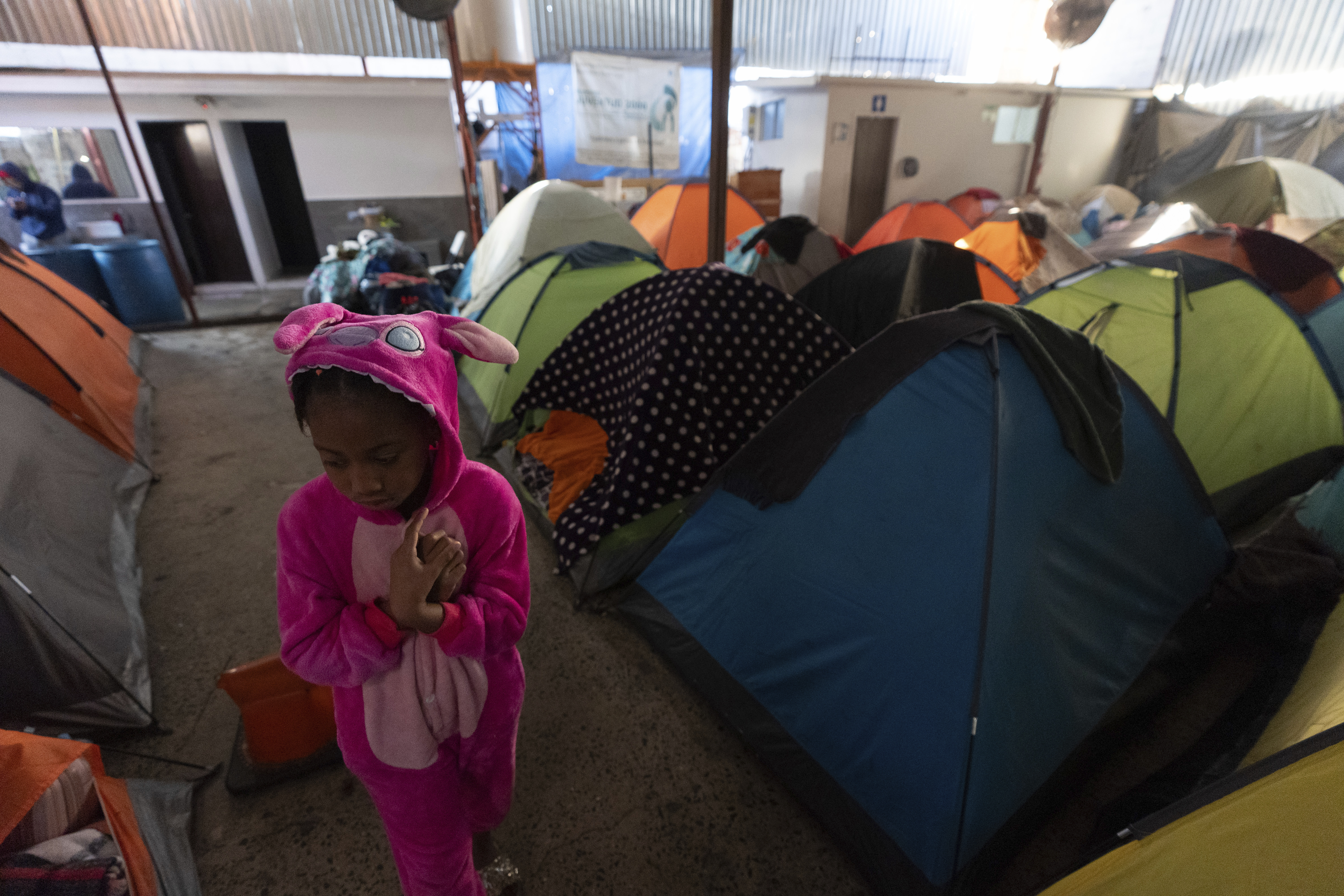 Maickeliys Rodriguez, 6, of Venezuela, leaves her tent at a migrant shelter on a chilly morning in Tijuana, Mexico, Saturday, Feb. 1, 2025. (AP Photo/Gregory Bull)