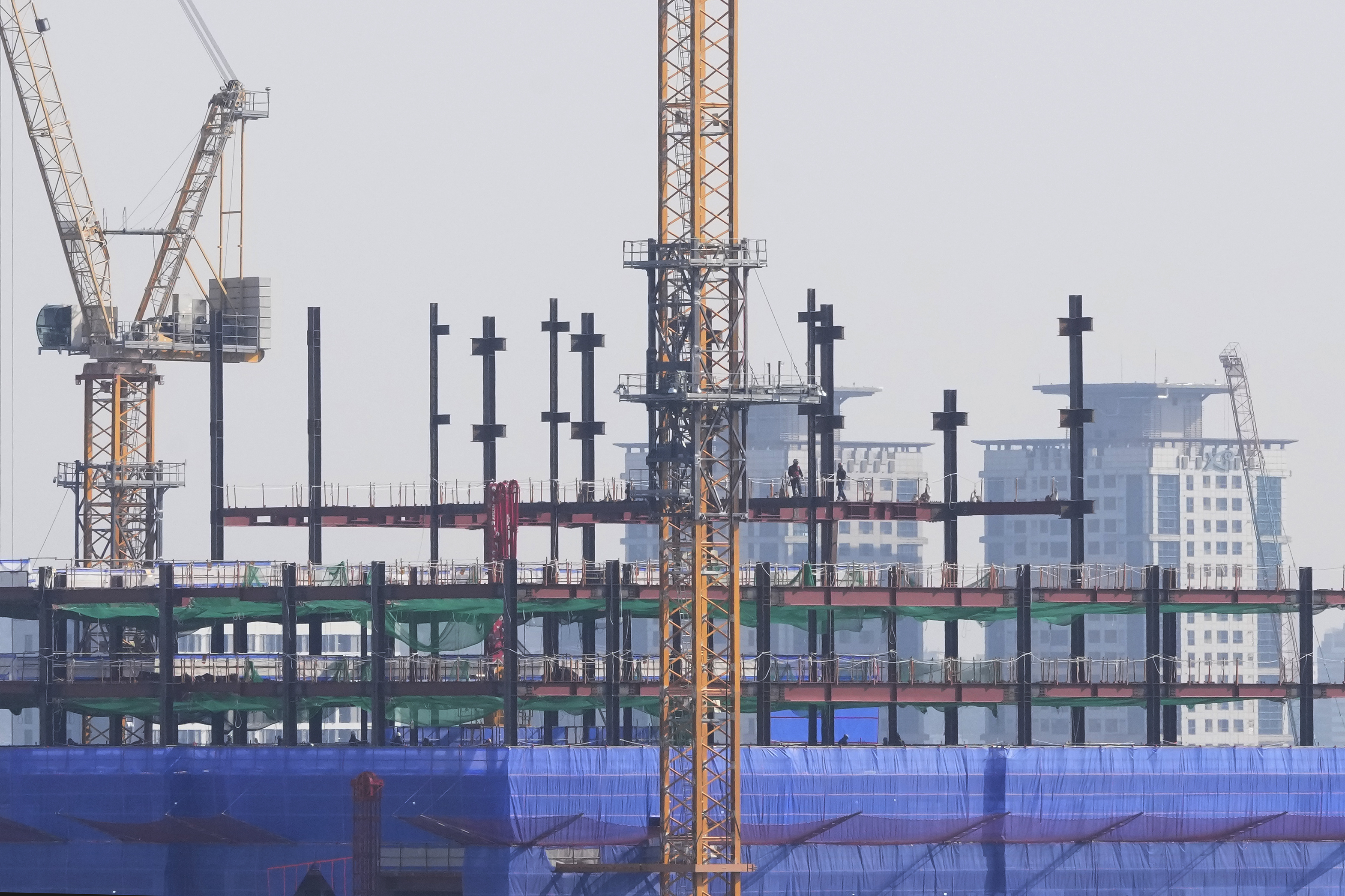 Labors work at a construction site in Seoul, South Korea, Tuesday, Feb. 11, 2025. (AP Photo/Ahn Young-joon)