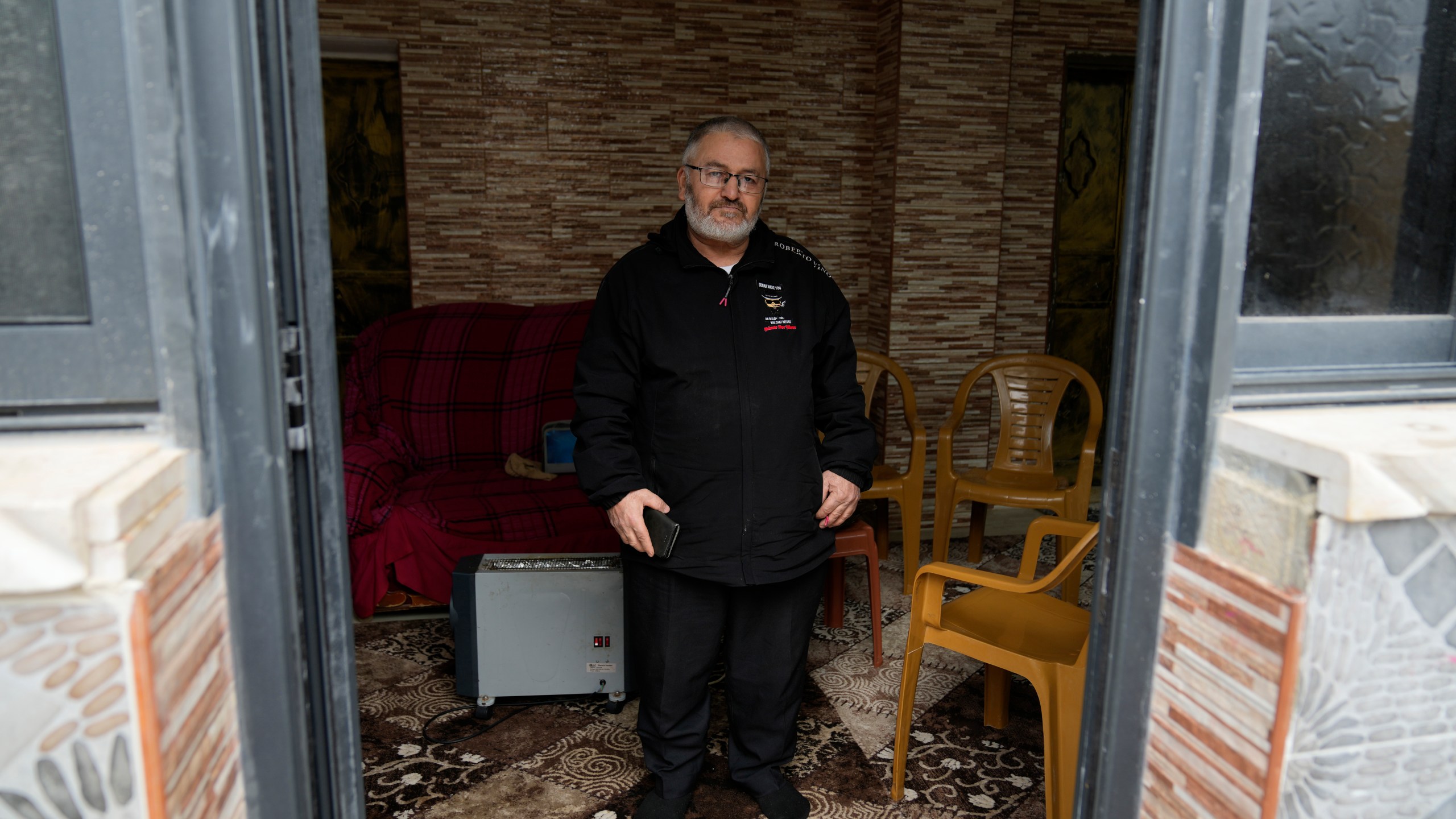 Mohammed Shula poses for a photo inside a relative's house where he and his wife have taken refuge at the West Bank village of Kafr al-Labad, Monday, Feb. 10, 2025. (AP Photo/Nasser Nasser)