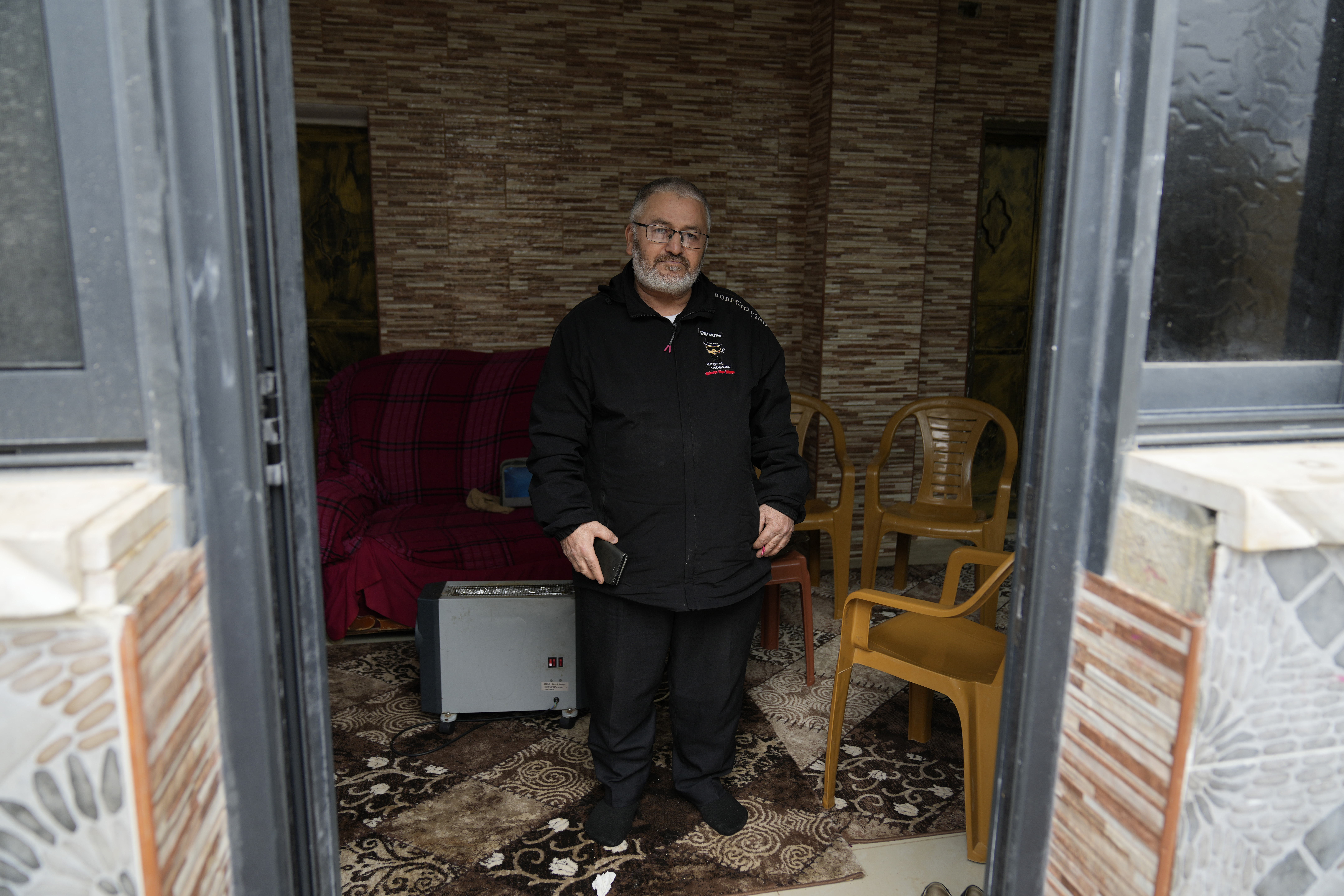 Mohammed Shula poses for a photo inside a relative's house where he and his wife have taken refuge at the West Bank village of Kafr al-Labad, Monday, Feb. 10, 2025. (AP Photo/Nasser Nasser)