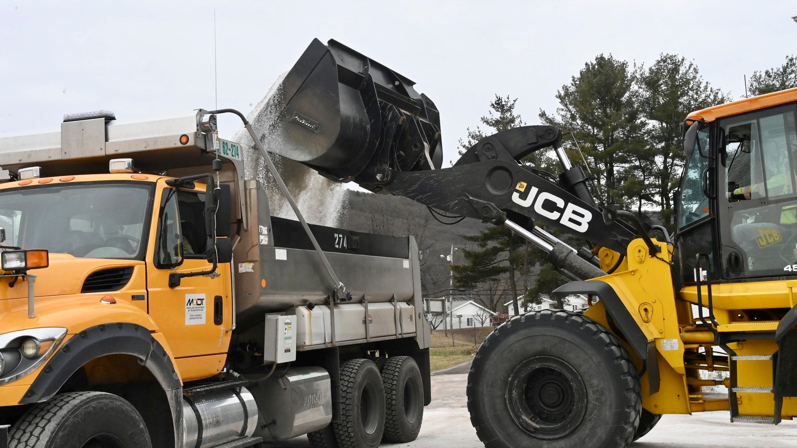 Maryland Department of Transportation employees use a backhoe to load a truck with salt at the State Highway Administration District 6 Office in LaVale, Md., Wednesday, Feb. 5, 2025. (Steve Bittner/Cumberland Times-News via AP)