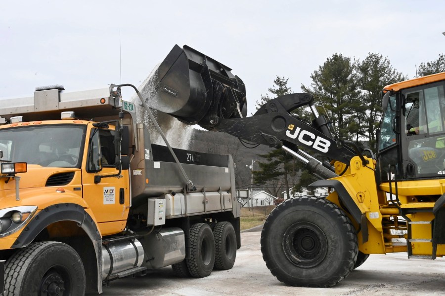 Maryland Department of Transportation employees use a backhoe to load a truck with salt at the State Highway Administration District 6 Office in LaVale, Md., Wednesday, Feb. 5, 2025. (Steve Bittner/Cumberland Times-News via AP)