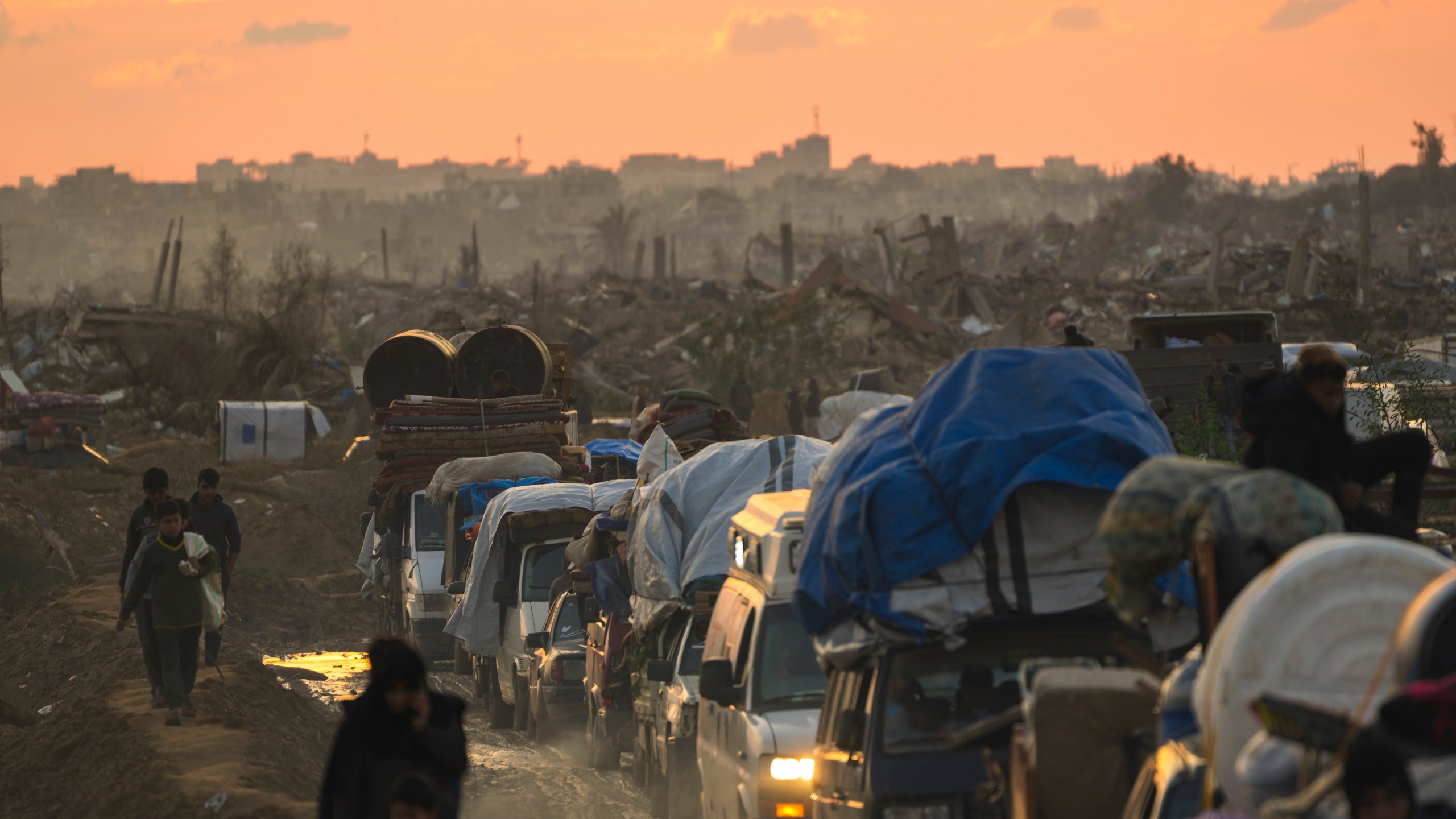 Displaced Palestinians, traveling in vehicles, wait in line to pass through a security checkpoint at the Netzarim corridor as they make their way from central Gaza to their homes in the northern Gaza Strip, Monday, Feb. 10, 2025. (AP Photo/Abdel Kareem Hana)