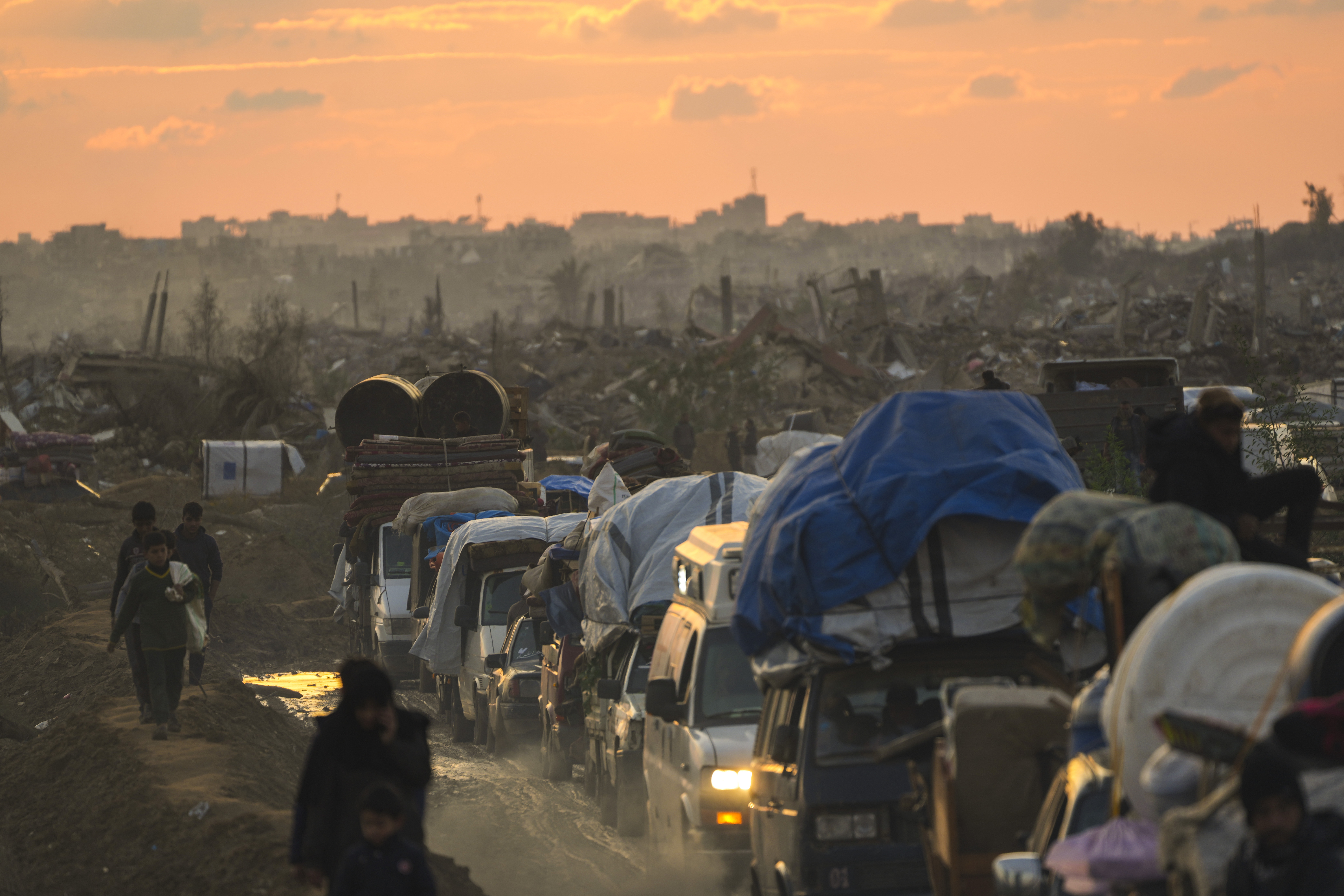 Displaced Palestinians, traveling in vehicles, wait in line to pass through a security checkpoint at the Netzarim corridor as they make their way from central Gaza to their homes in the northern Gaza Strip, Monday, Feb. 10, 2025. (AP Photo/Abdel Kareem Hana)