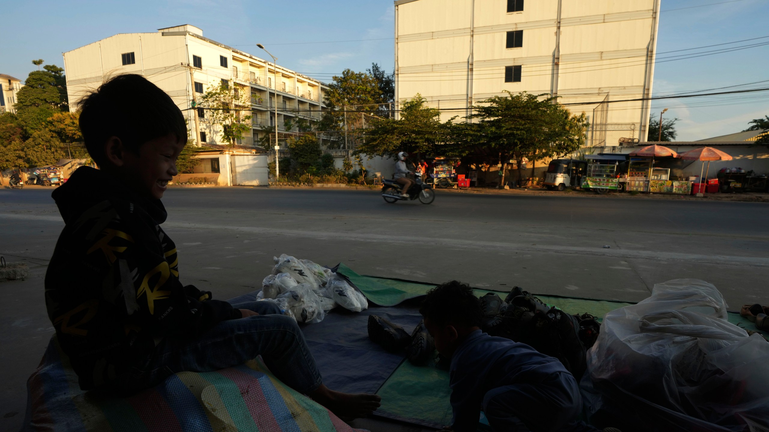 A boy plays near a building, where some people trafficked under false pretenses are forced to work in online scams targeting people all over the world, in Phnom Penh, Cambodia, Sunday, Feb. 9, 2025. (AP Photo/Heng Sinith)