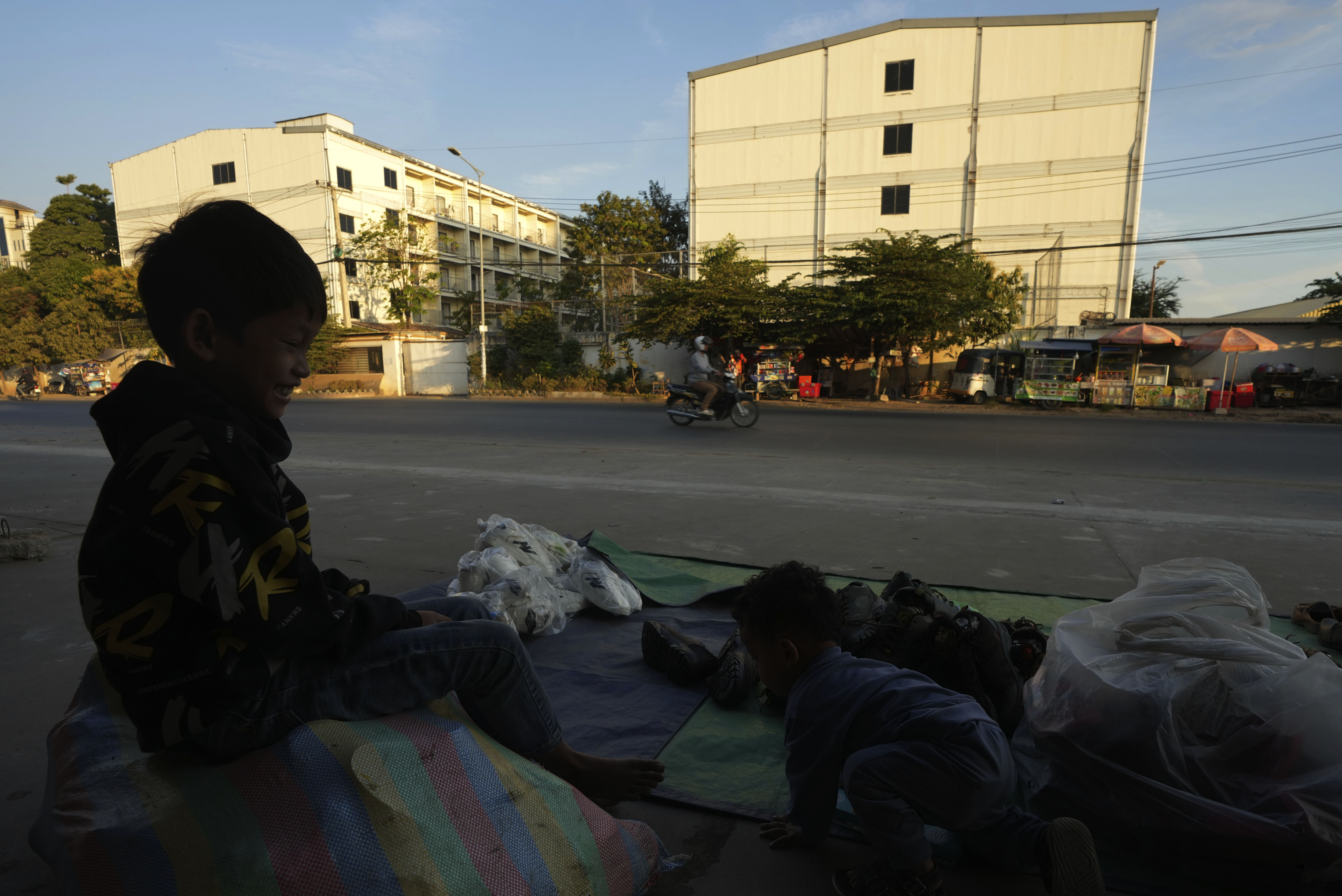 A boy plays near a building, where some people trafficked under false pretenses are forced to work in online scams targeting people all over the world, in Phnom Penh, Cambodia, Sunday, Feb. 9, 2025. (AP Photo/Heng Sinith)