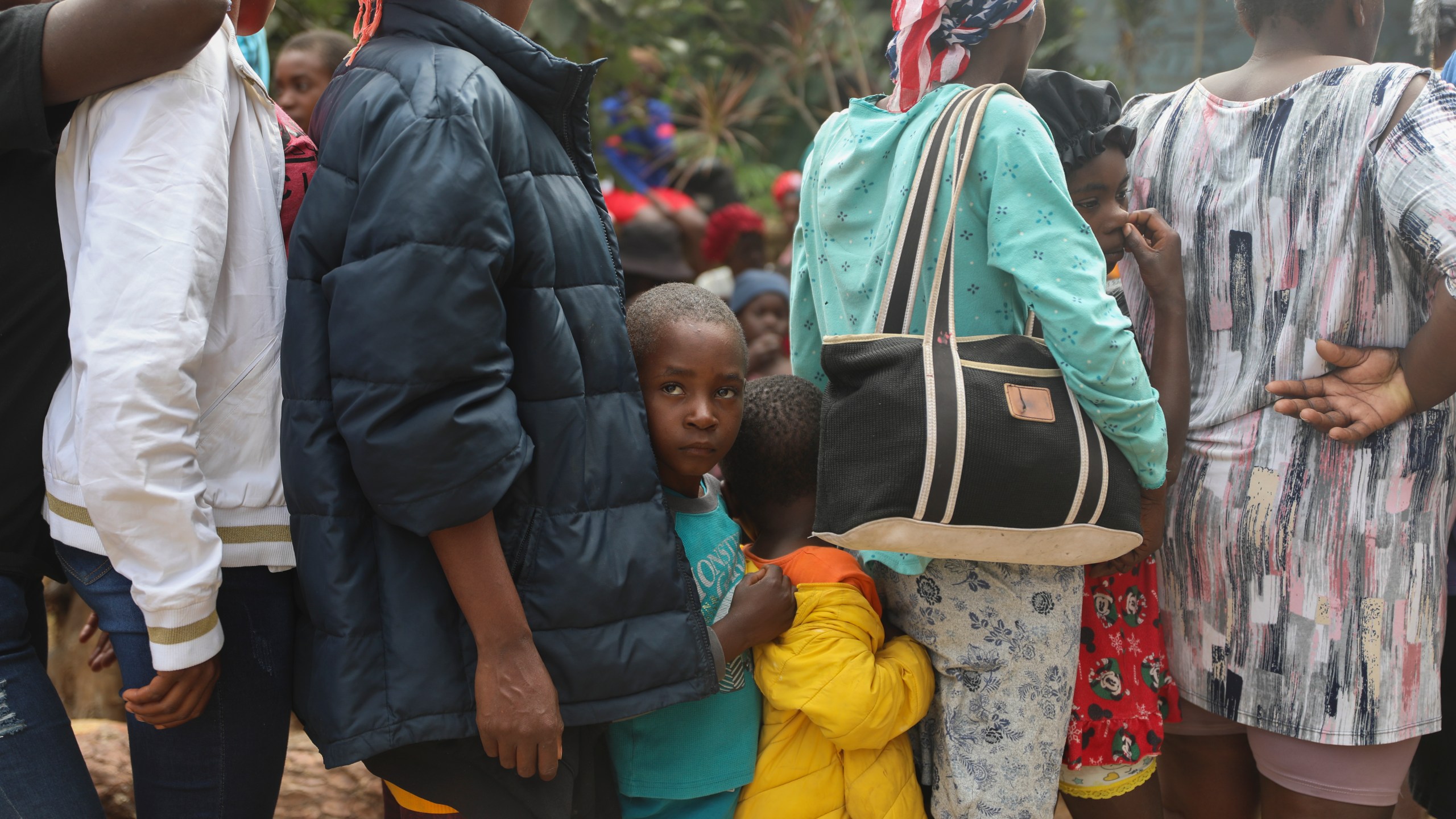 People line up to receive food at a shelter for families displaced by gang violence in the Kenscoff neighborhood of Port-au-Prince, Haiti, Monday, Feb. 3, 2025. (AP Photo/Odelyn Joseph)