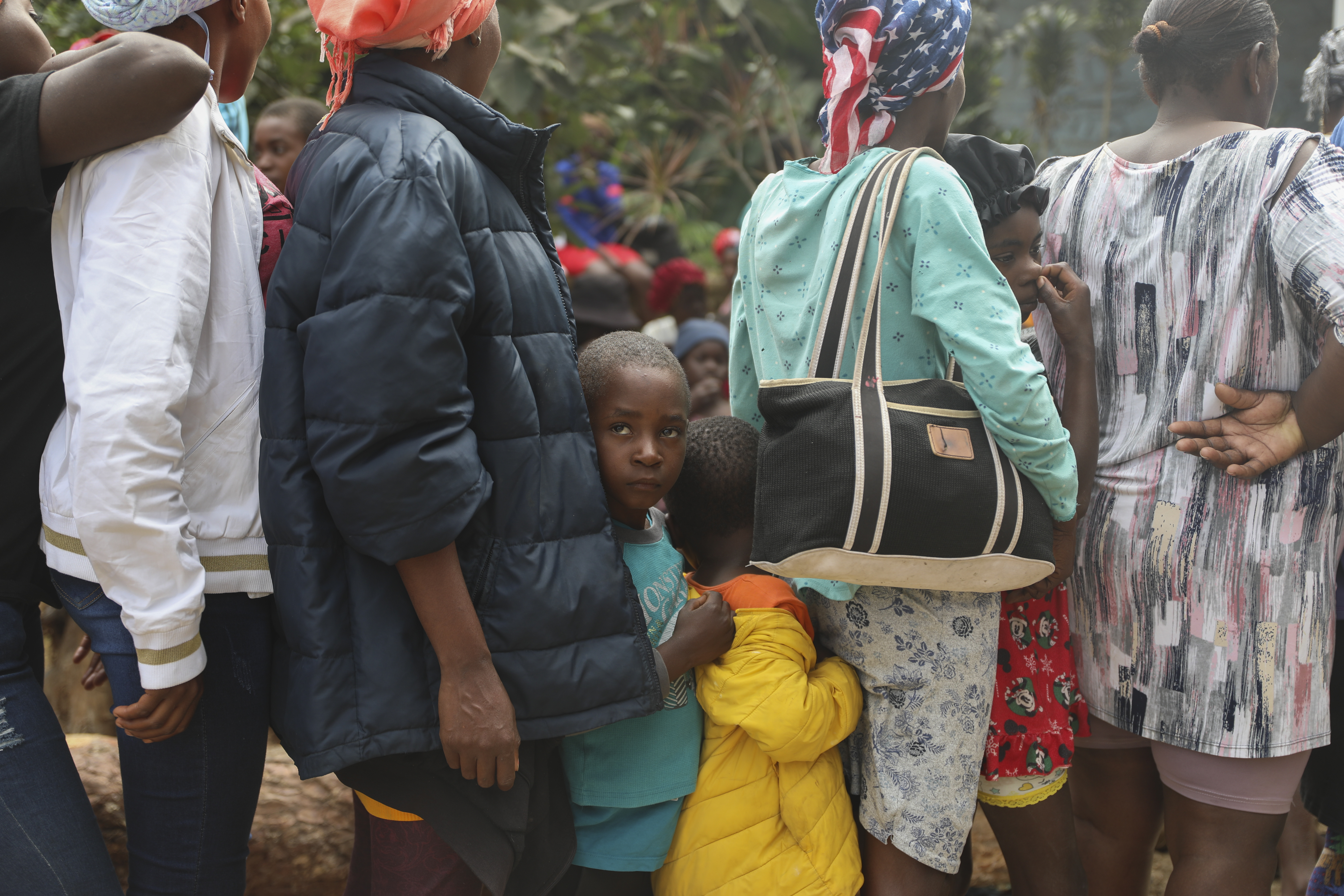 People line up to receive food at a shelter for families displaced by gang violence in the Kenscoff neighborhood of Port-au-Prince, Haiti, Monday, Feb. 3, 2025. (AP Photo/Odelyn Joseph)