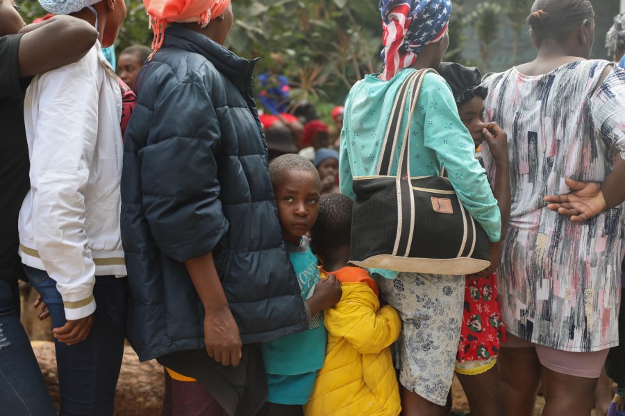 People line up to receive food at a shelter for families displaced by gang violence in the Kenscoff neighborhood of Port-au-Prince, Haiti, Monday, Feb. 3, 2025. (AP Photo/Odelyn Joseph)