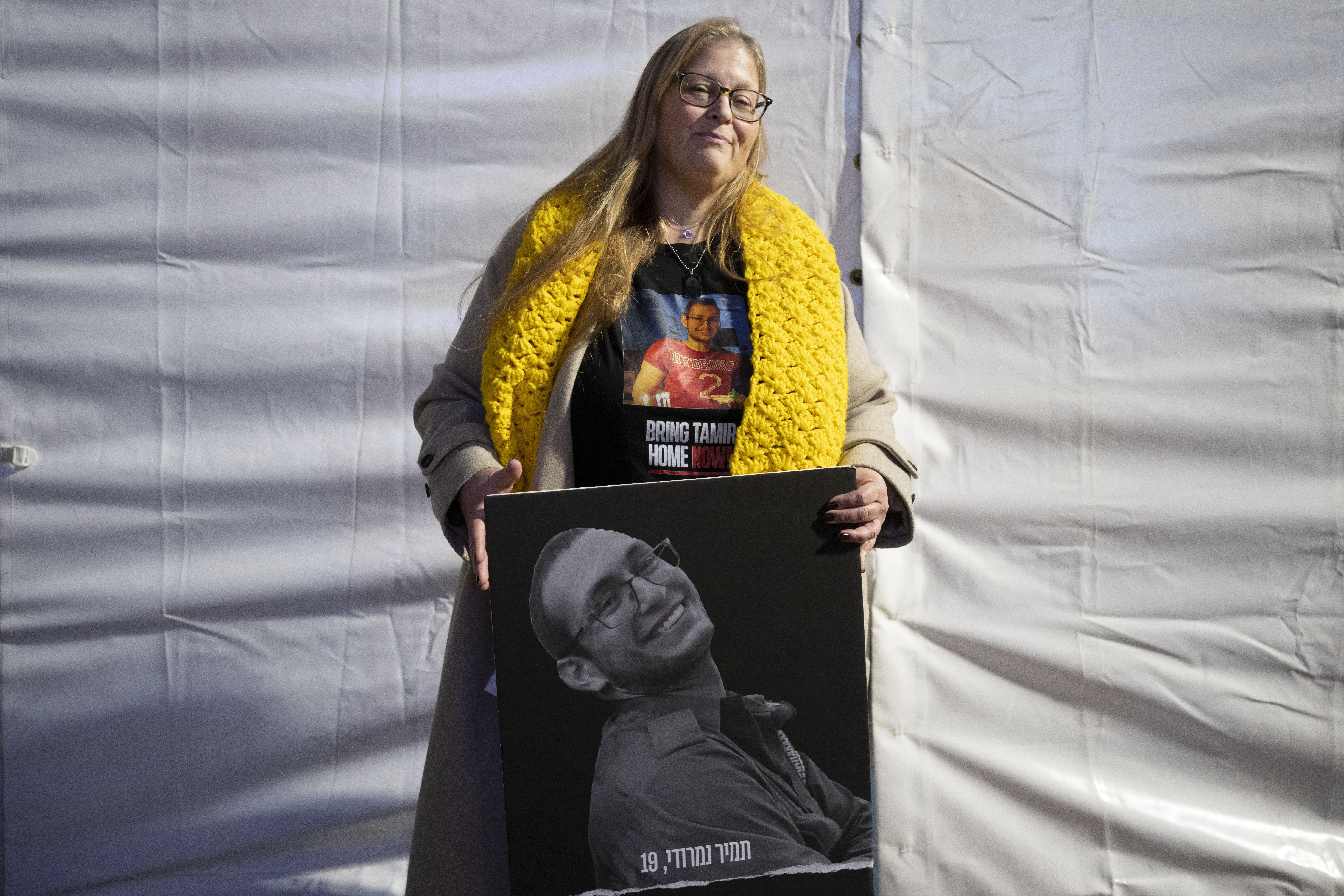 FILE - Herut Nimrodi poses for a portrait with a poster of her son, Tamir Nimrodi, an Israeli soldier taken hostage on Oct. 7, 2023, and being held by Hamas militants in the Gaza Strip, at a rally for hostages and their families in Tel Aviv, Israel, Jan. 14, 2025. (AP Photo/Maya Alleruzzo, File)