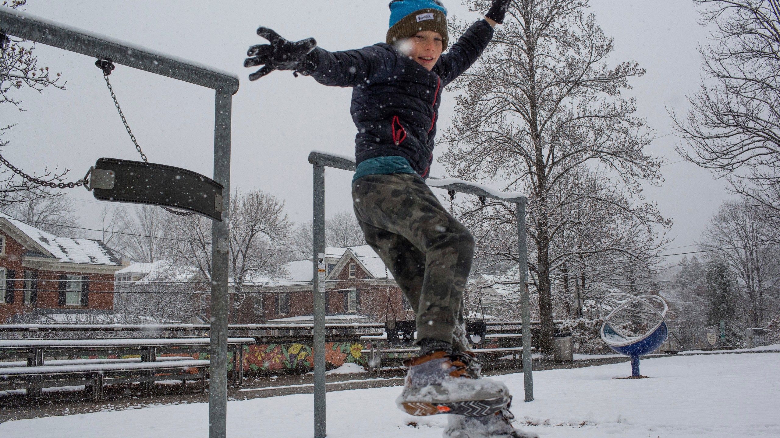 Will Bowles jumps off a swing set during a winter snowstorm in Charlottesville, Va., Tuesday, Feb. 11, 2025. (Cal Cary/The Daily Progress via AP)