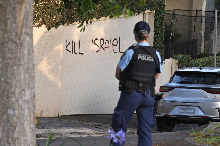 A police officer stands near where anti-Israel graffiti is painted on a wall in Sydney, Australia, on Dec. 11, 2024. (Mick Tsikas/AAP Image via AP)y