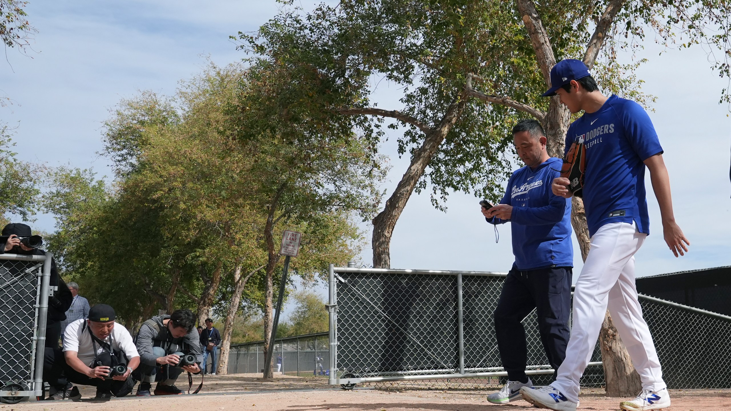 Los Angeles Dodgers' Shohei Ohtani, right, of Japan, walks back to the clubhouse at the Dodgers baseball spring training facility after working out Tuesday, Feb. 11, 2025, in Phoenix. (AP Photo/Ross D. Franklin)