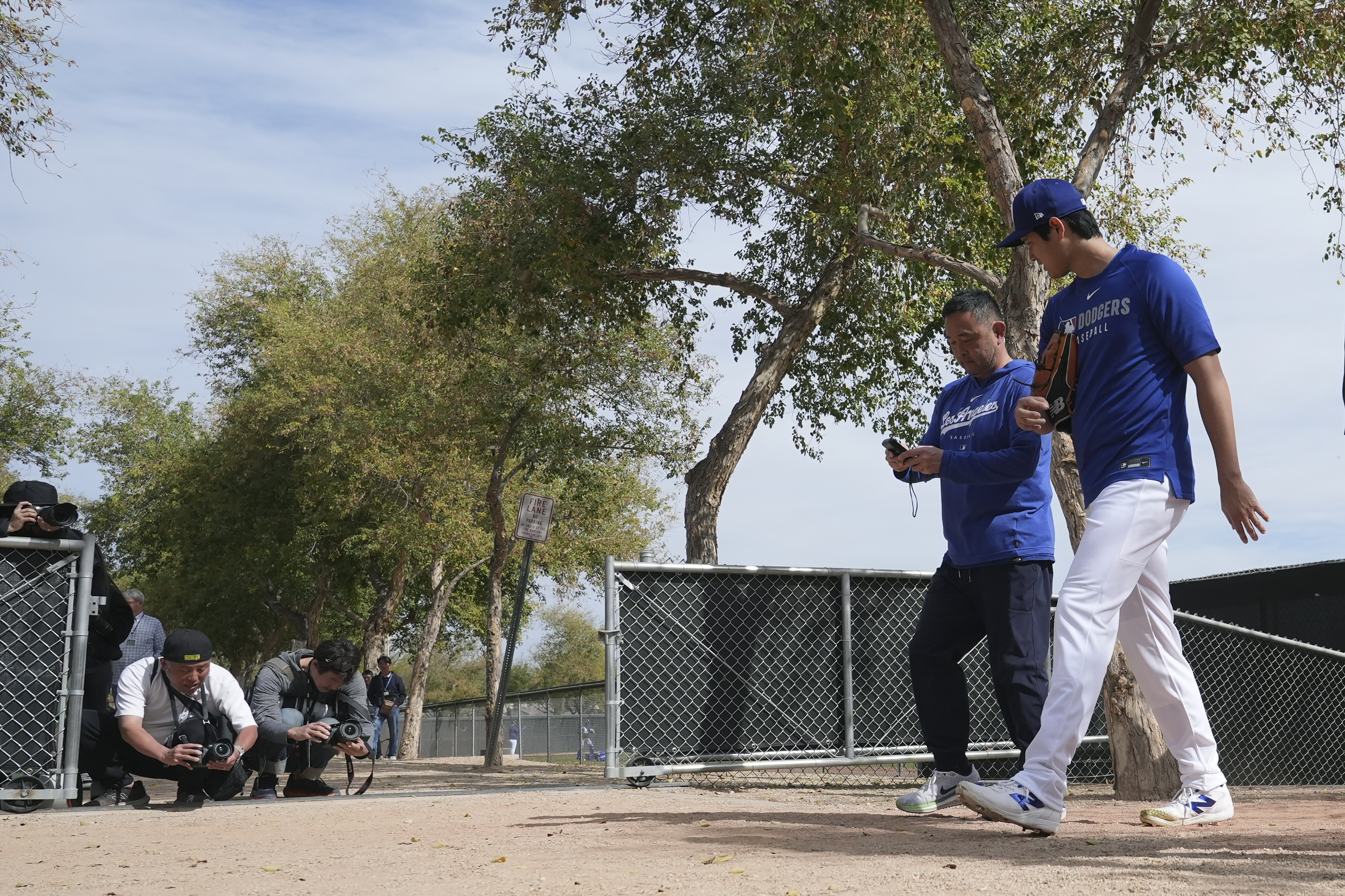 Los Angeles Dodgers' Shohei Ohtani, right, of Japan, walks back to the clubhouse at the Dodgers baseball spring training facility after working out Tuesday, Feb. 11, 2025, in Phoenix. (AP Photo/Ross D. Franklin)