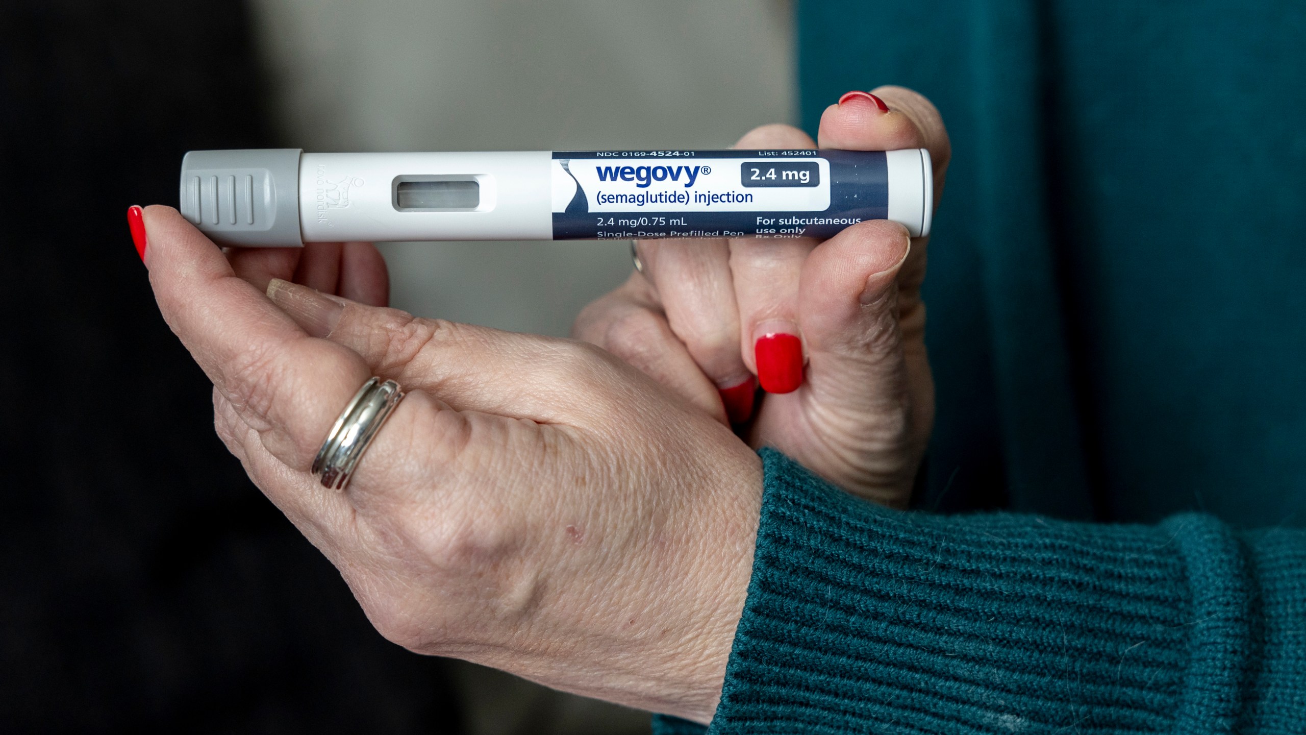 FILE - A woman holds up a dosage of Wegovy, a drug used for weight loss, at her home in Front Royal, Va., on March 1, 2024. (AP Photo/Amanda Andrade-Rhoades, File)