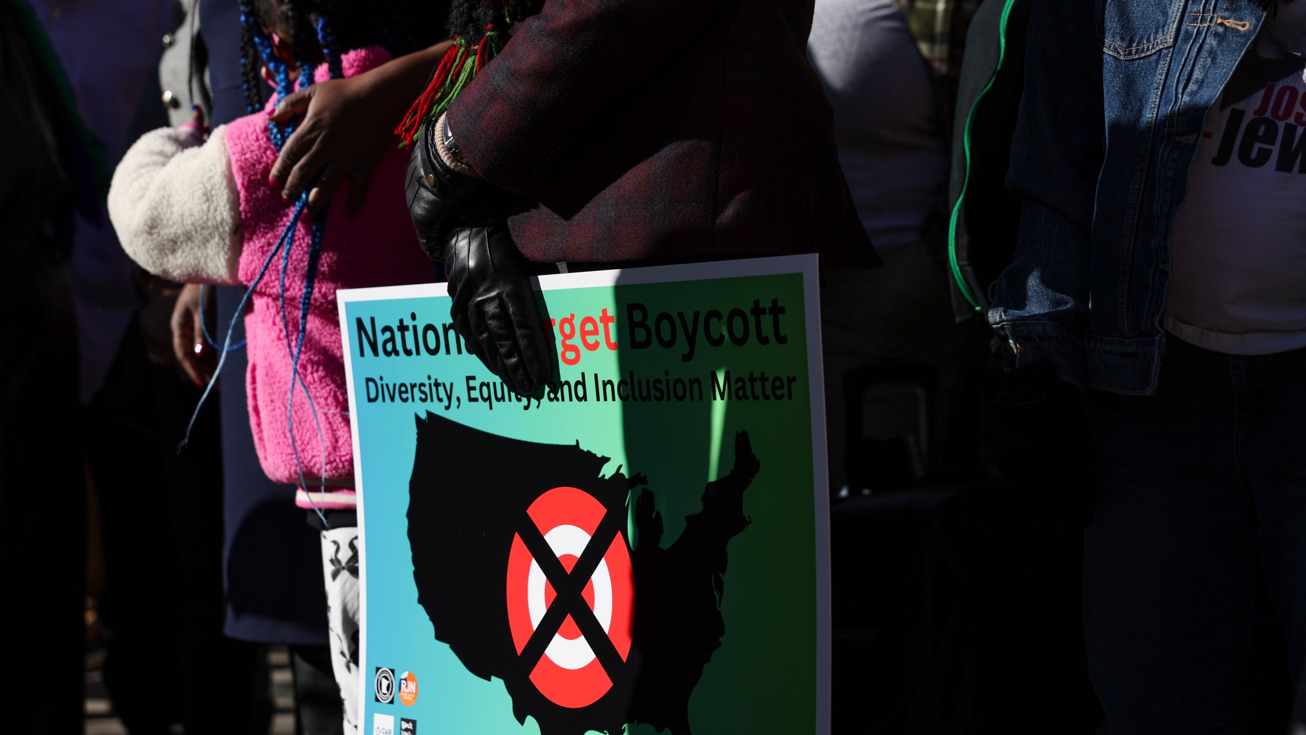 FILE - A community member holds a sign calling for a national boycott of Target stores during a news conference outside Target Corporation's headquarters Thursday, Jan. 30, 2025, in Minneapolis, Minn. (AP Photo/Ellen Schmidt, File)