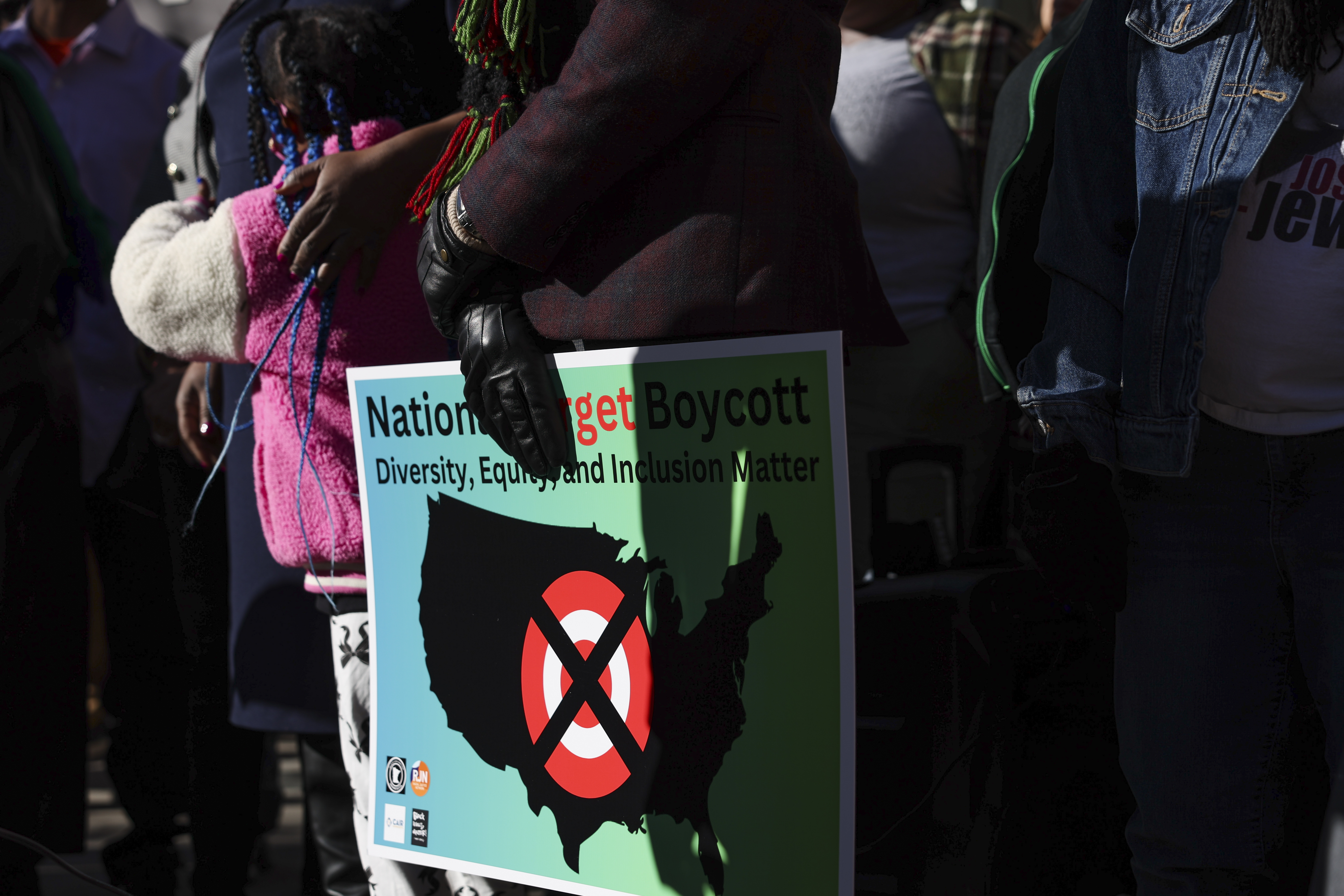 FILE - A community member holds a sign calling for a national boycott of Target stores during a news conference outside Target Corporation's headquarters Thursday, Jan. 30, 2025, in Minneapolis, Minn. (AP Photo/Ellen Schmidt, File)