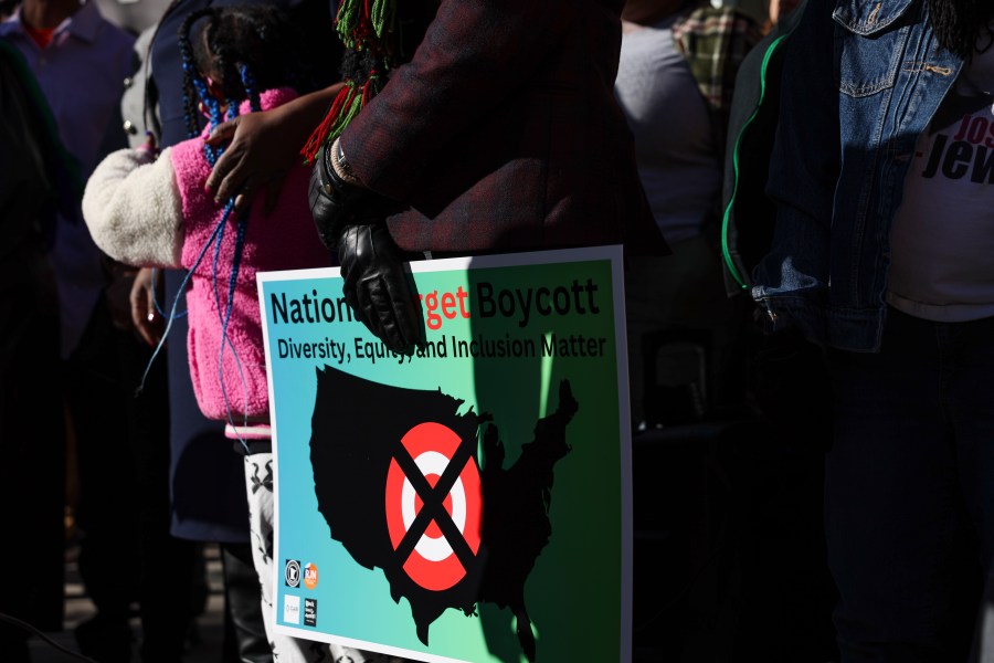 FILE - A community member holds a sign calling for a national boycott of Target stores during a news conference outside Target Corporation's headquarters Thursday, Jan. 30, 2025, in Minneapolis, Minn. (AP Photo/Ellen Schmidt, File)