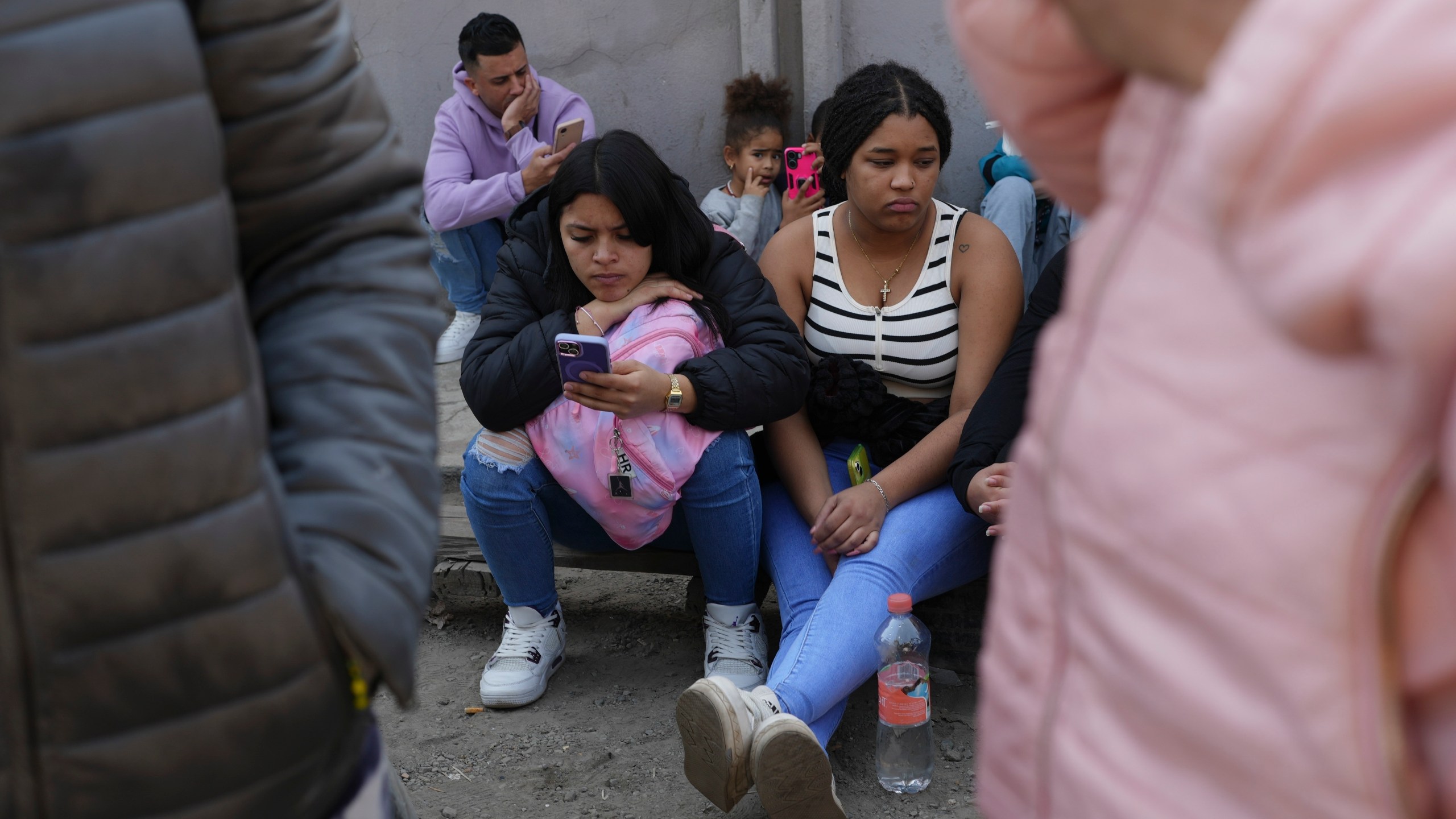 Migrants wait outside the Mexican Commission for Refugee Aid (COMAR) government office to apply for asylum in Mexico City, Tuesday, Jan. 28, 2025. (AP Photo/Marco Ugarte)