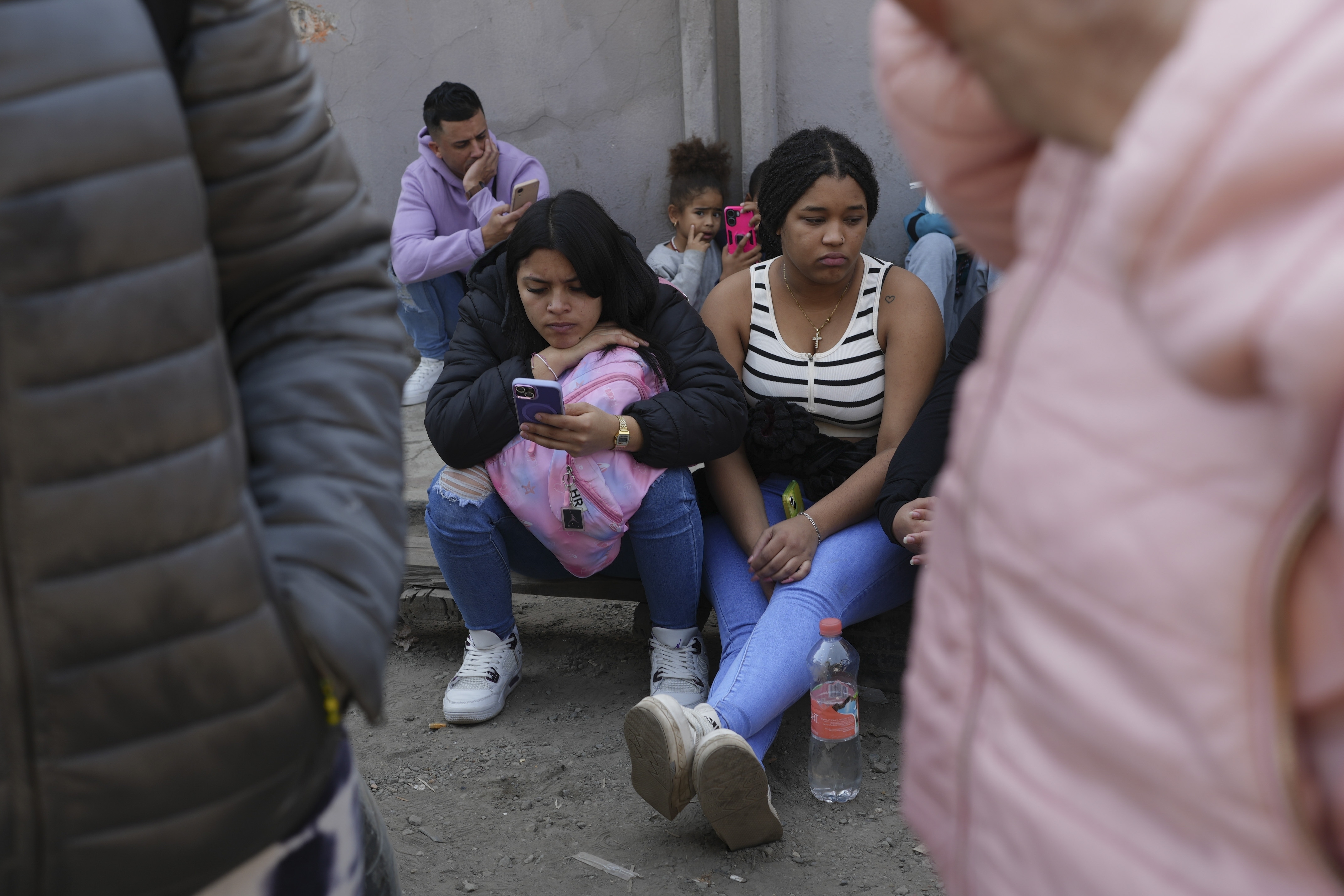 Migrants wait outside the Mexican Commission for Refugee Aid (COMAR) government office to apply for asylum in Mexico City, Tuesday, Jan. 28, 2025. (AP Photo/Marco Ugarte)