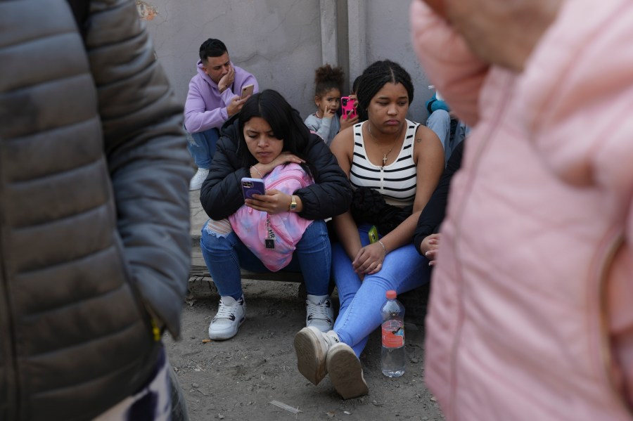 Migrants wait outside the Mexican Commission for Refugee Aid (COMAR) government office to apply for asylum in Mexico City, Tuesday, Jan. 28, 2025. (AP Photo/Marco Ugarte)