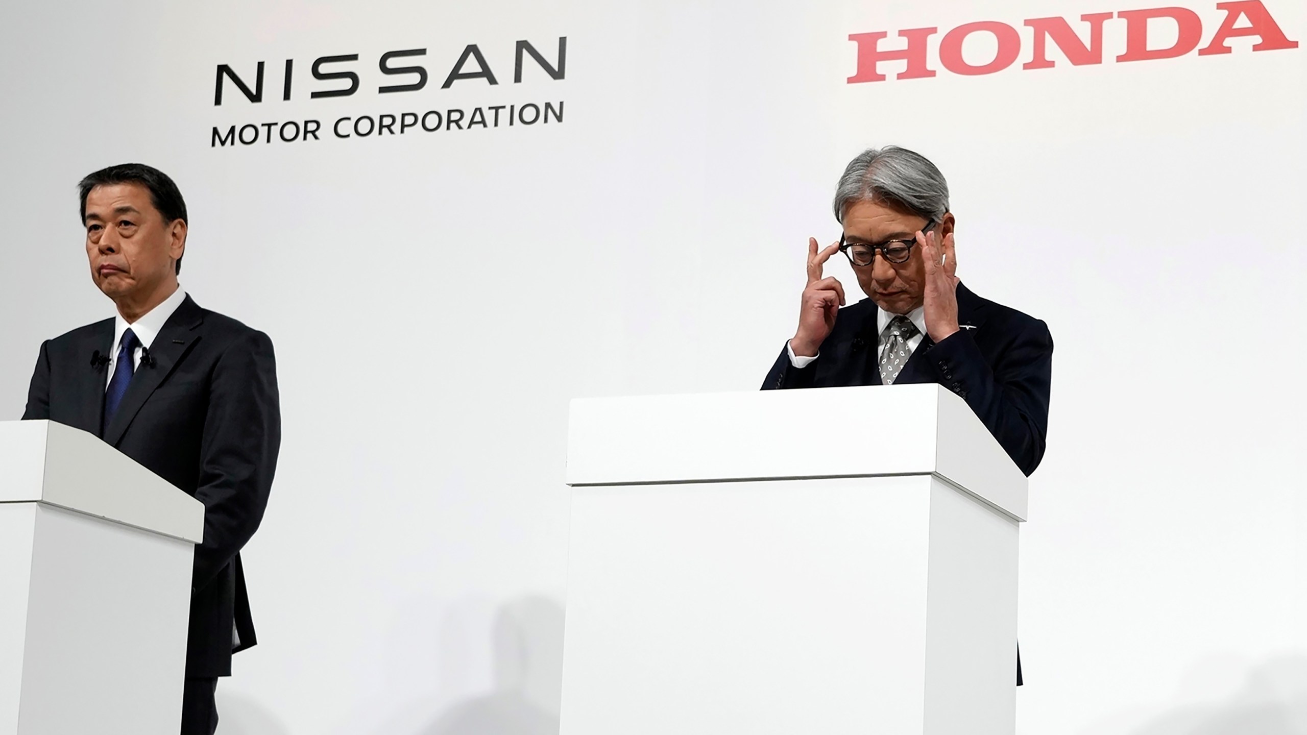 FILE - Nissan Chief Executive Makoto Uchida, left, and Honda Chief Executive Toshihiro Mibe, right, along with Takao Kato CEO of Mitsubishi Motors, not in photo, attend a joint news conference Monday, Dec. 23, 2024, in Tokyo, Japan. (AP Photo/Eugene Hoshiko, File)