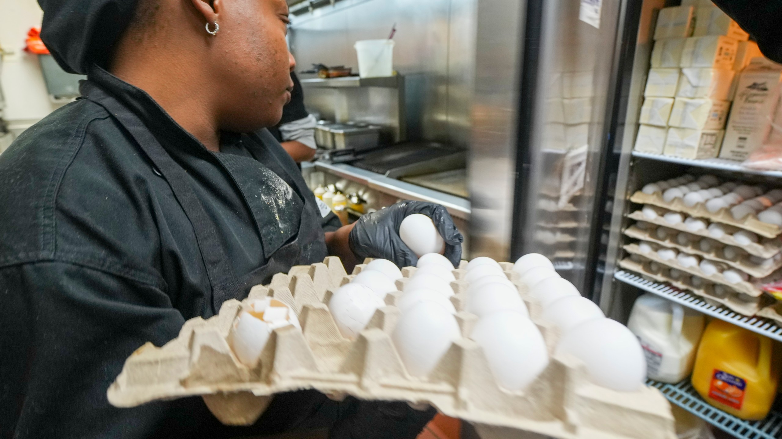 Johkiya Pierre holds a carton of eggs while preparing a fresh omelette at The Breakfast Brothers restaurant, Wednesday, Feb. 12, 2025, in Arlington, Texas. (AP Photo/Julio Cortez)