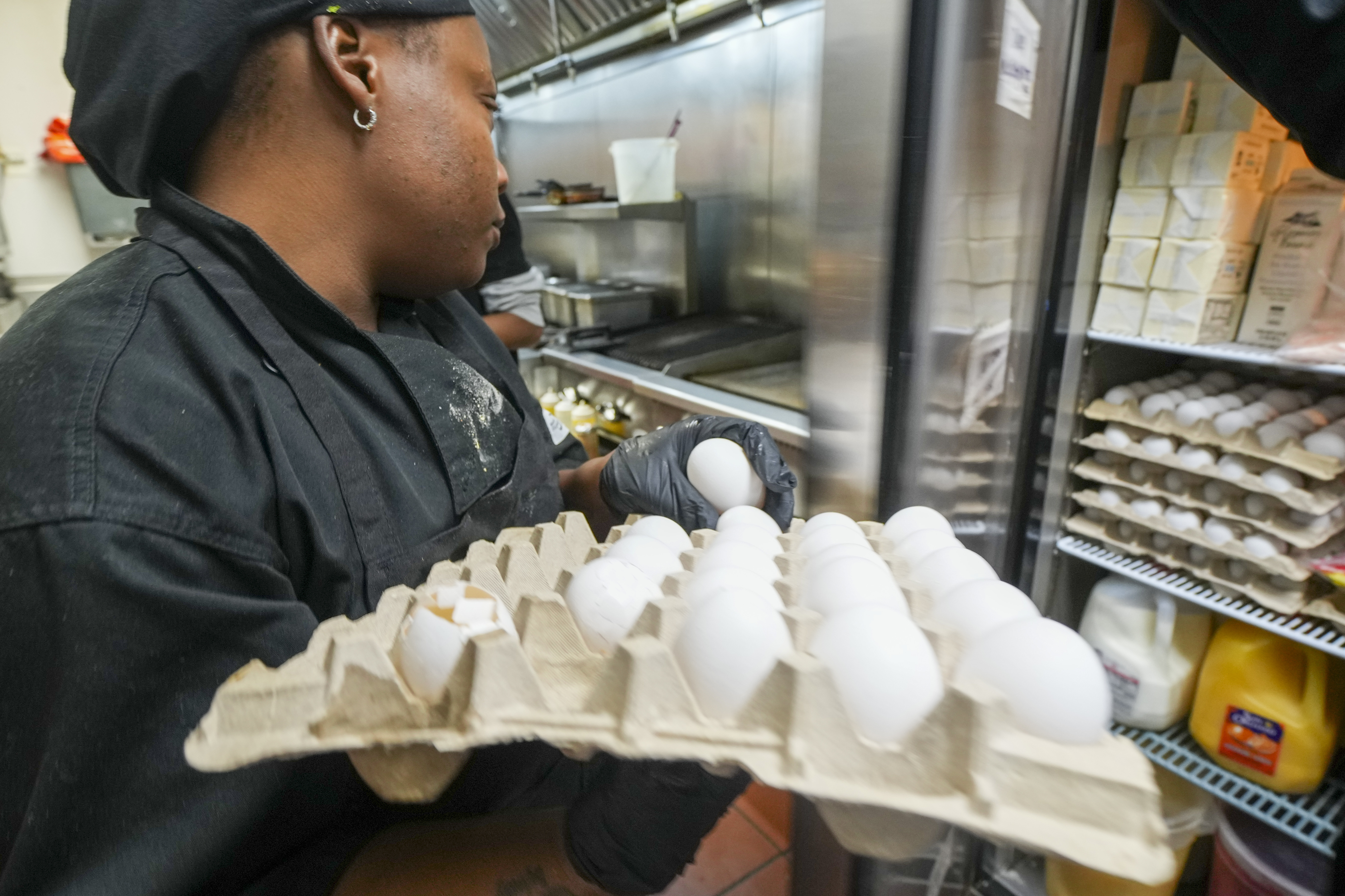 Johkiya Pierre holds a carton of eggs while preparing a fresh omelette at The Breakfast Brothers restaurant, Wednesday, Feb. 12, 2025, in Arlington, Texas. (AP Photo/Julio Cortez)