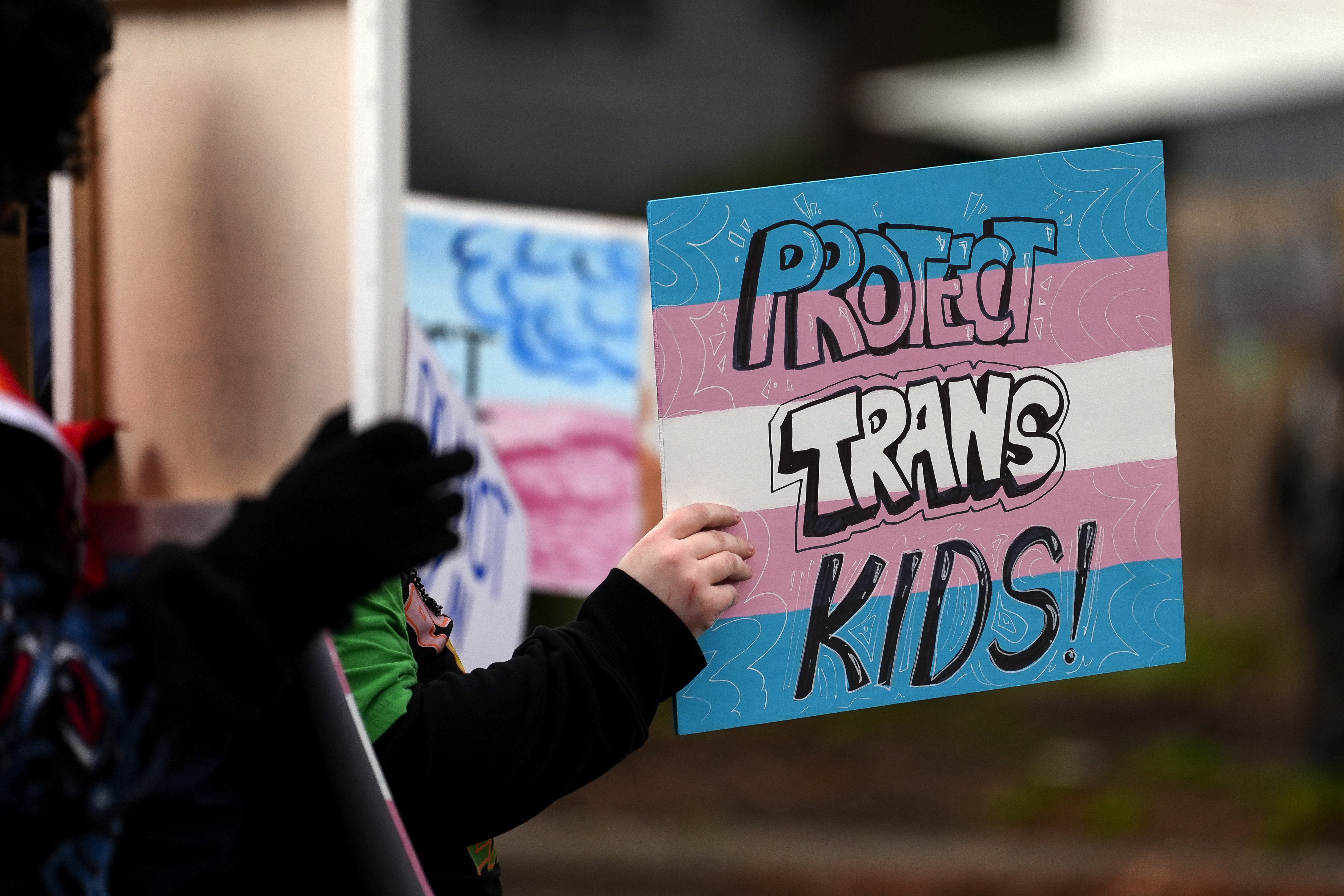 FILE - A person holds a sign during a pro-transgender rights protest outside of Seattle Children's Hospital after the institution postponed some gender-affirming surgeries for minors following an executive order by President Donald Trump, Sunday, Feb. 9, 2025, in Seattle. (AP Photo/Lindsey Wasson, File)