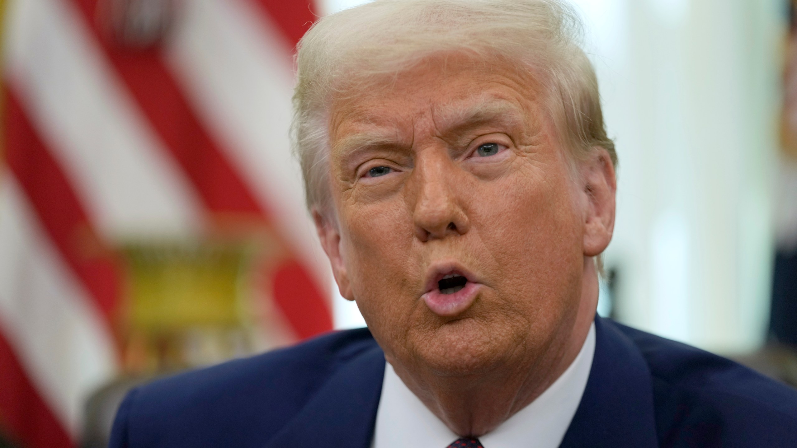 President Donald Trump speaks to reporters in the Oval Office of the White House, where he signed an executive order, Thursday, Feb. 13, 2025, in Washington. (AP Photo/Ben Curtis)