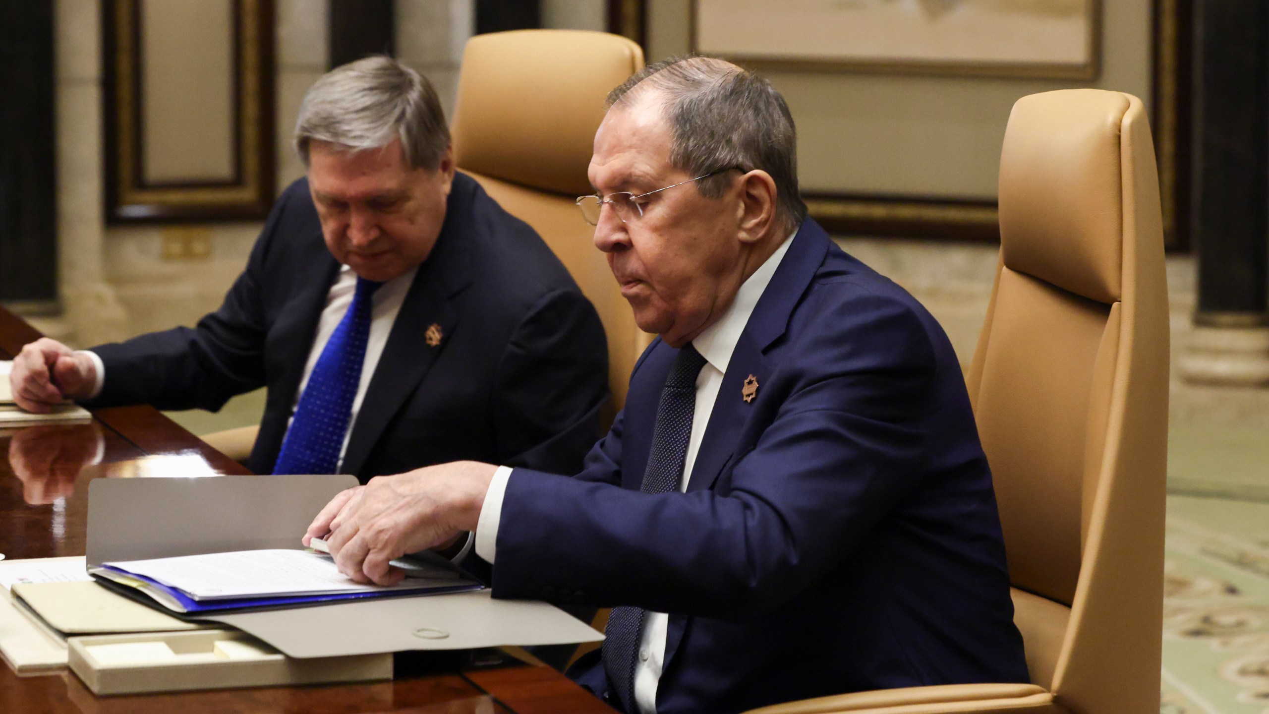 Russian Foreign Minister Sergei Lavrov, right, sits next to Russian President Vladimir Putin's foreign policy advisor Yuri Ushakov during a meeting with U.S. Secretary of State Marco Rubio, U.S. National Security Advisor Mike Waltz and U.S. Middle East envoy Steve Witkoff, Saudi Foreign Minister Prince Faisal bin Farhan Al Saud and Saudi National Security Advisor Mosaad bin Mohammad Al-Aiban, at Diriyah Palace, in Riyadh, Saudi Arabia, Tuesday, Feb. 18, 2025. (Evelyn Hockstein/Pool Photo via AP)