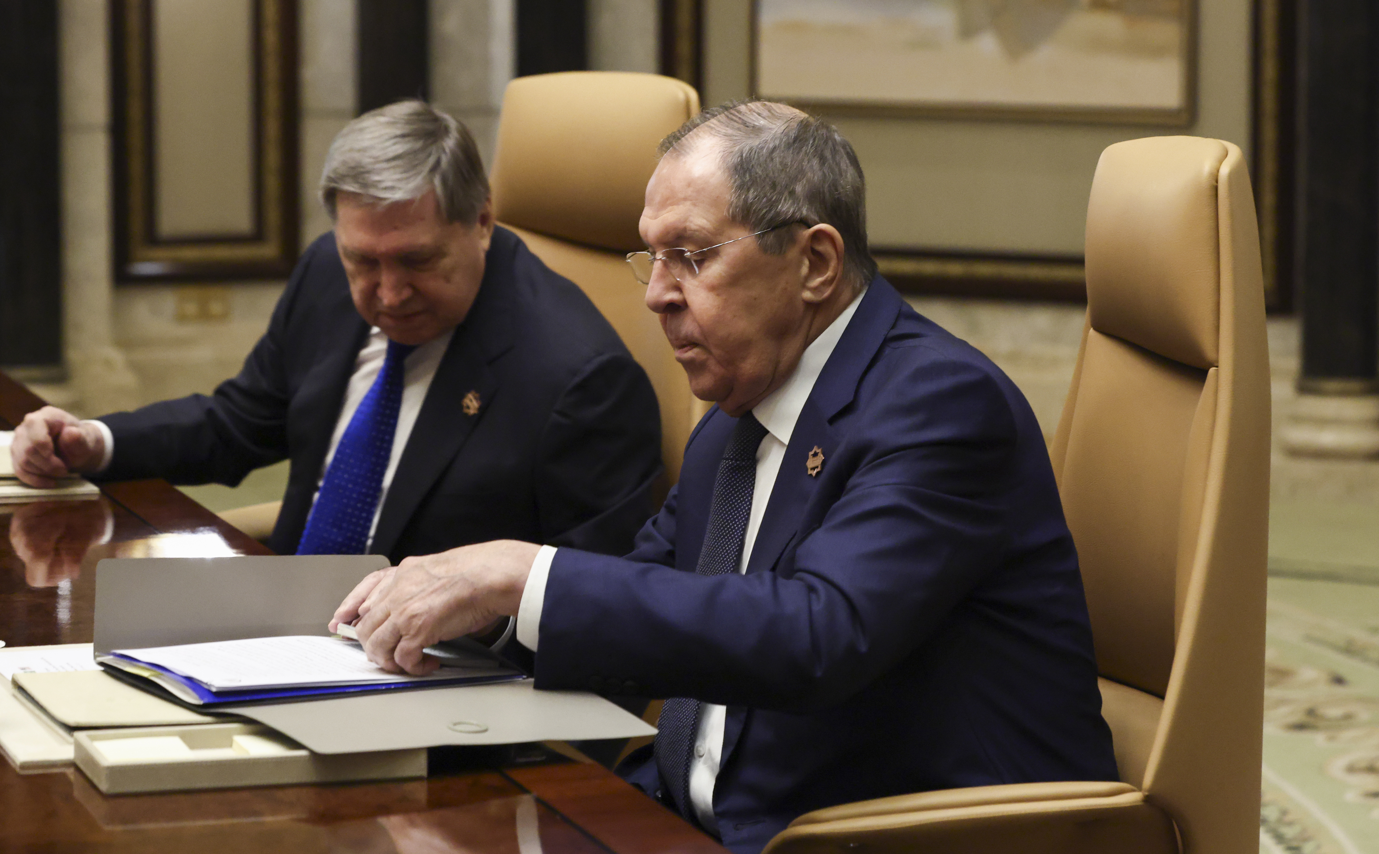 Russian Foreign Minister Sergei Lavrov, right, sits next to Russian President Vladimir Putin's foreign policy advisor Yuri Ushakov during a meeting with U.S. Secretary of State Marco Rubio, U.S. National Security Advisor Mike Waltz and U.S. Middle East envoy Steve Witkoff, Saudi Foreign Minister Prince Faisal bin Farhan Al Saud and Saudi National Security Advisor Mosaad bin Mohammad Al-Aiban, at Diriyah Palace, in Riyadh, Saudi Arabia, Tuesday, Feb. 18, 2025. (Evelyn Hockstein/Pool Photo via AP)