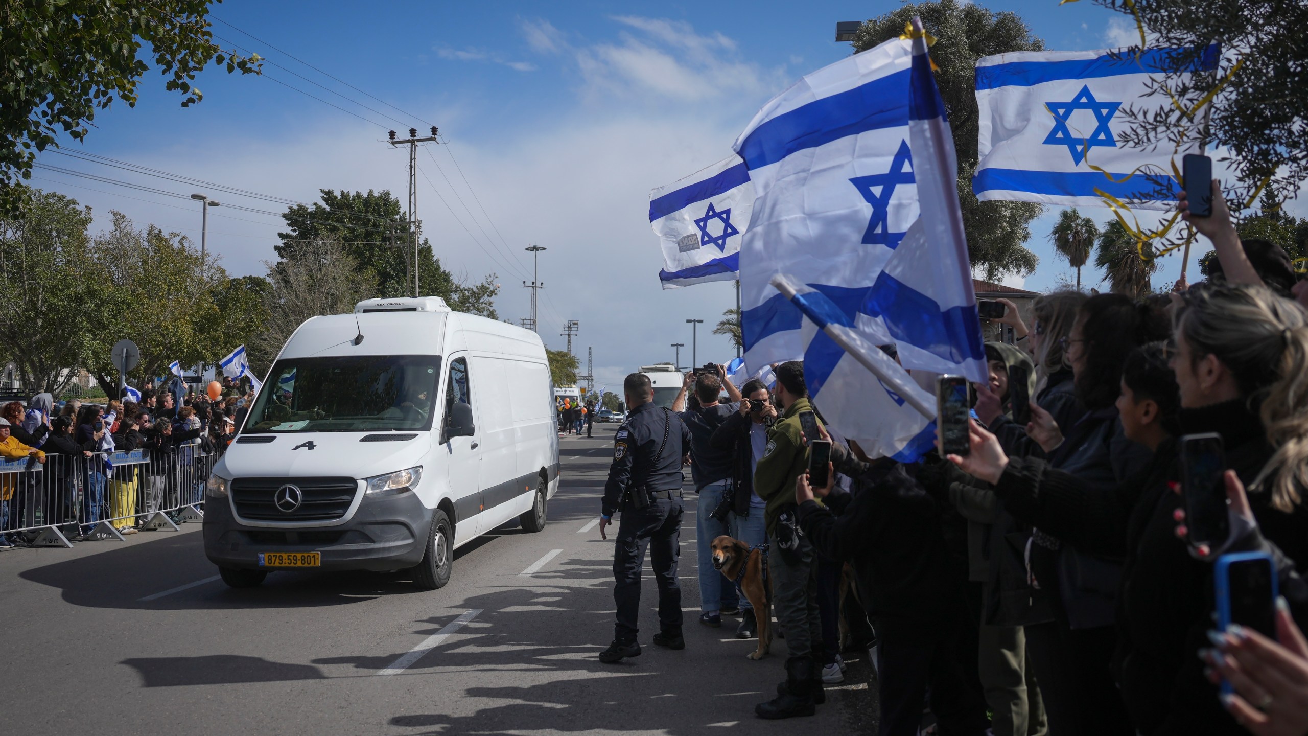 The convoy carrying the coffins of four Israeli hostages, including a mother and her two children, arrives at the Abu Kabir Forensic Institute in Tel Aviv, Israel, Thursday Feb. 20, 2025 after they were handed over by Palestinian militant groups in Gaza.(AP Photo/Ohad Zwigenberg)