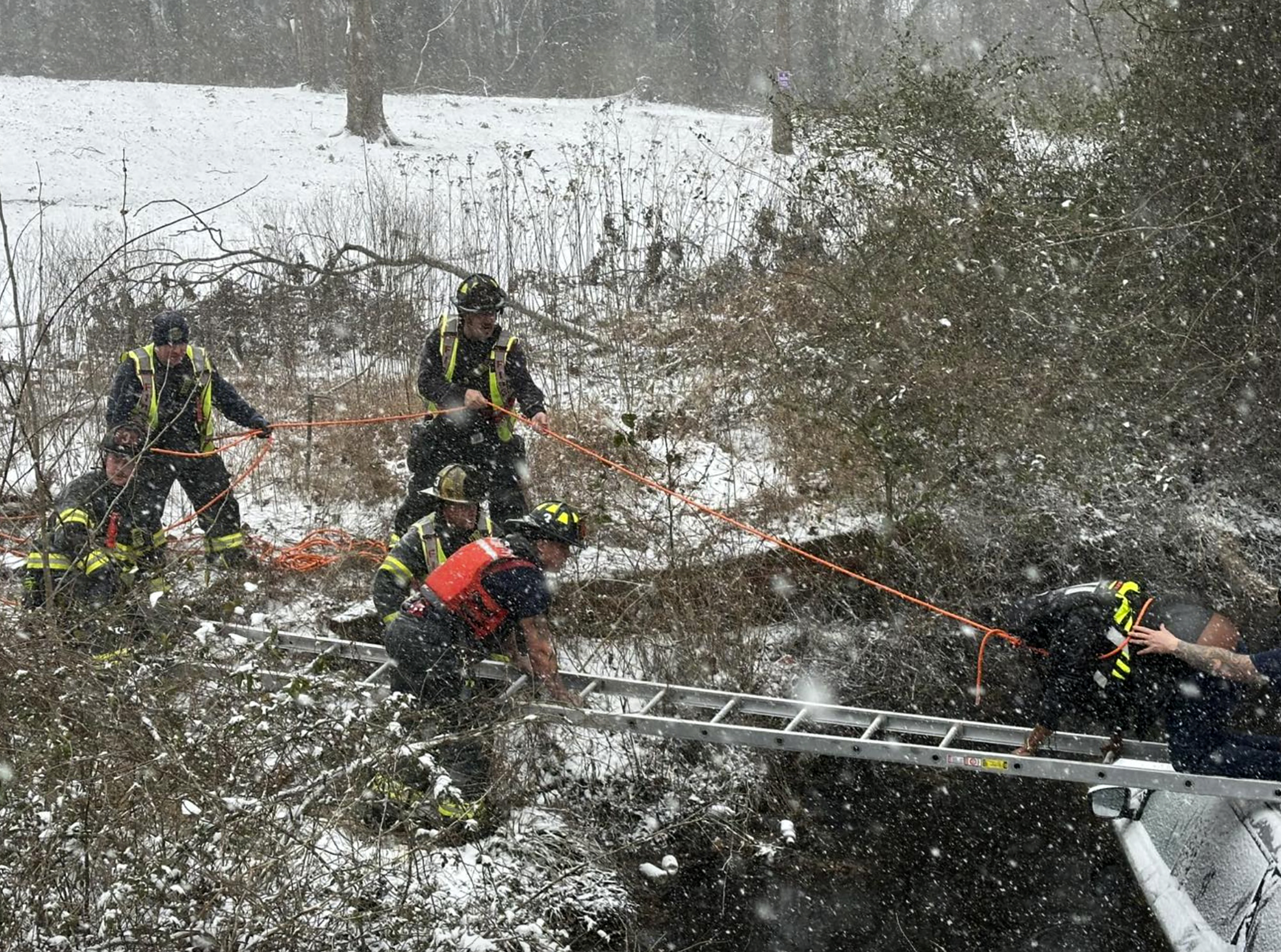 This image provided by the City of Suffolk Department of Fire & Rescue shows emergency workers rescuing a person from an SUV that crashed into water Wednesday, Feb. 19, 2025 in Suffolk, Va. (City of Suffolk Department of Fire & Rescue via AP)