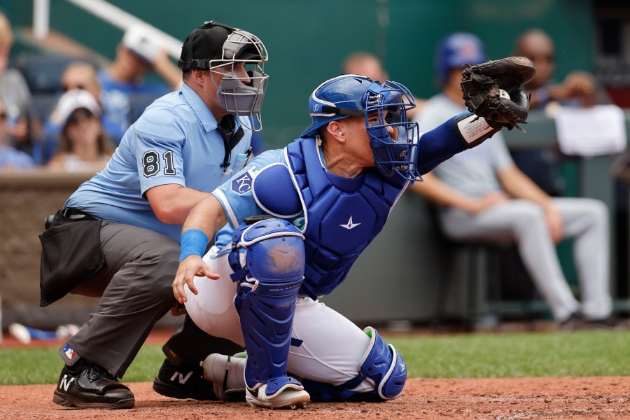 FILE - Kansas City Royals catcher Freddy Fermin (34) takes a pitch as home plate umpire Quinn Wolcott (81) calls the balls and strikes during a baseball game against the Chicago Cubs in Kansas City, Mo., Sunday, July 28, 2024. (AP Photo/Colin E. Braley, File)