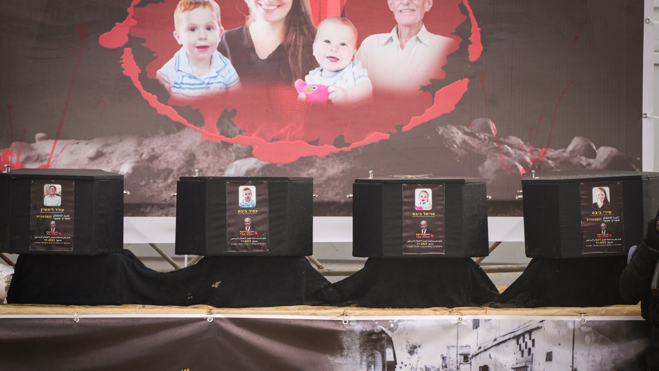 The coffins containing the bodies, from right to left, Shiri Bibas, her two children, Ariel and Kfir and Oded Lifshitz, who was 83 when he was abducted, are displayed on a stage before being handed over to the Red Cross by Hamas and Islamic Jihad in Khan Younis, southern Gaza Strip, Thursday, Feb. 20, 2025. (AP Photo/Abdel Kareem Hana)