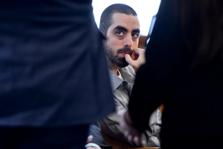 Hadi Matar, charged with severely injuring author Salman Rushdie in a 2022 knife attack, listens to his defense team in Chautauqua County court in Mayville, N.Y., Thursday, Feb. 20, 2025. (AP Photo/Adrian Kraus)