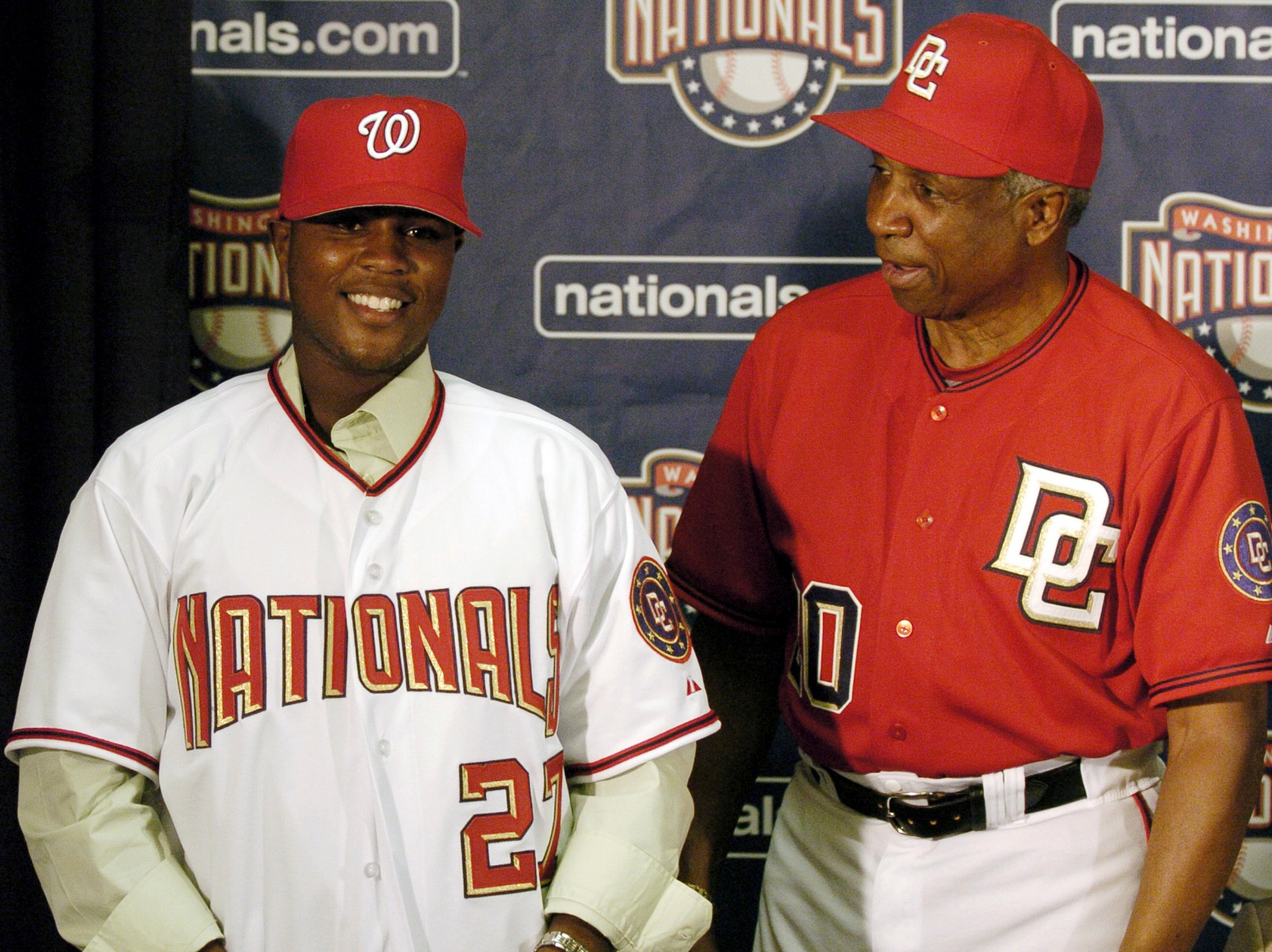 FILE - Washington Nationals manager Frank Robinson, right, introduces Dominican Esmailyn González, an amateur free-agent shortstop who had taken four years off his age to appear younger, at a media presentation in Washington, July 2, 2006. Carlos Álvarez, formerly known as Esmailyn "Smiley" González, played for three years with the Washington Nationals before the MLB learned that he was lying about his age. (AP Photo/Nick Wass, File)