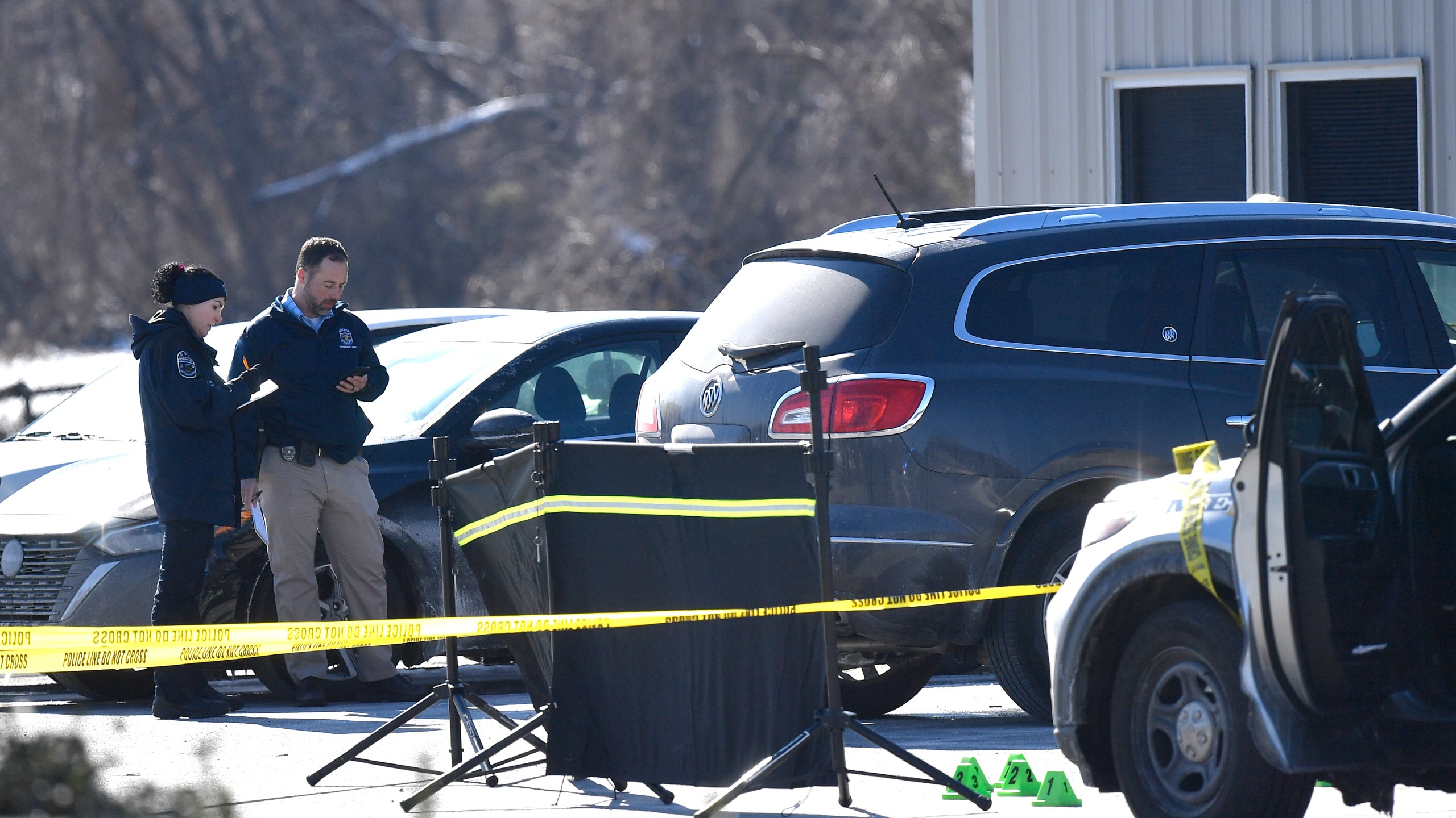 Detectives with the Louisville Metro Crime Scene unit examines a scene of a deadly shooting outside a motor vehicle office in Louisville, Ky., Friday, Feb. 21, 2025. (AP Photo/Timothy D. Easley)